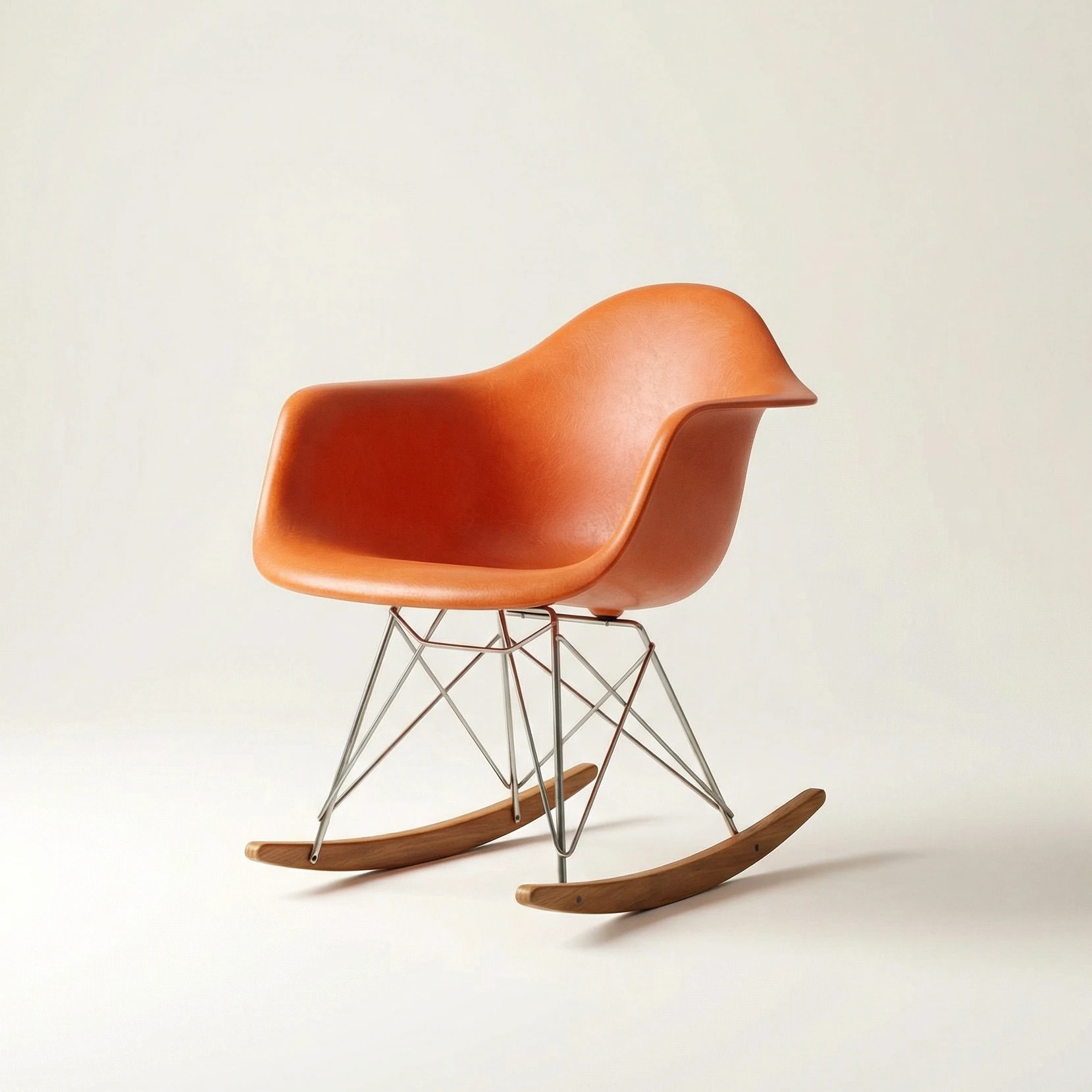 Smiling young woman with curly hair sitting at a laptop, in front of a teal wall.