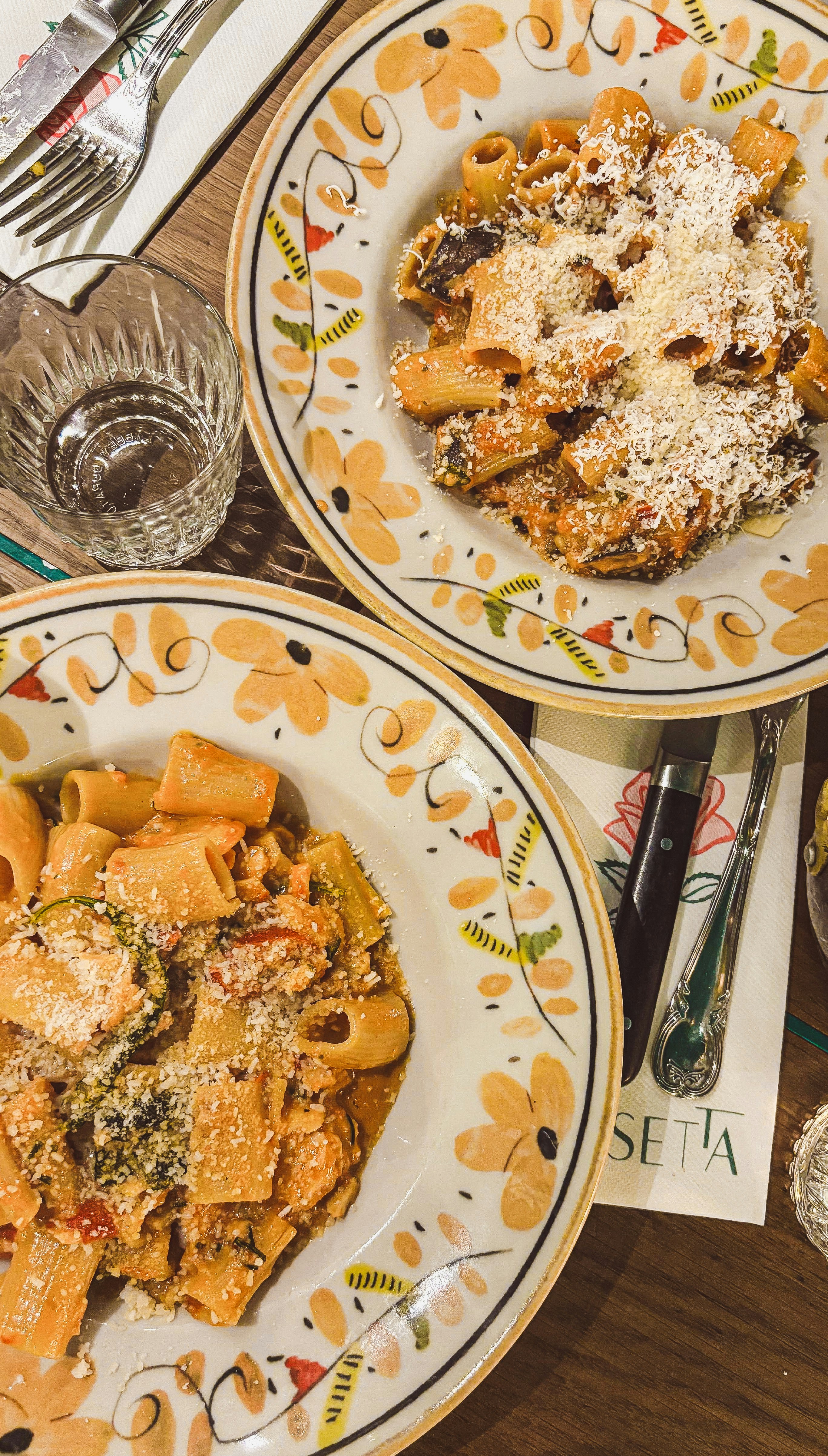 Pasta dishes served on decorative plates.
