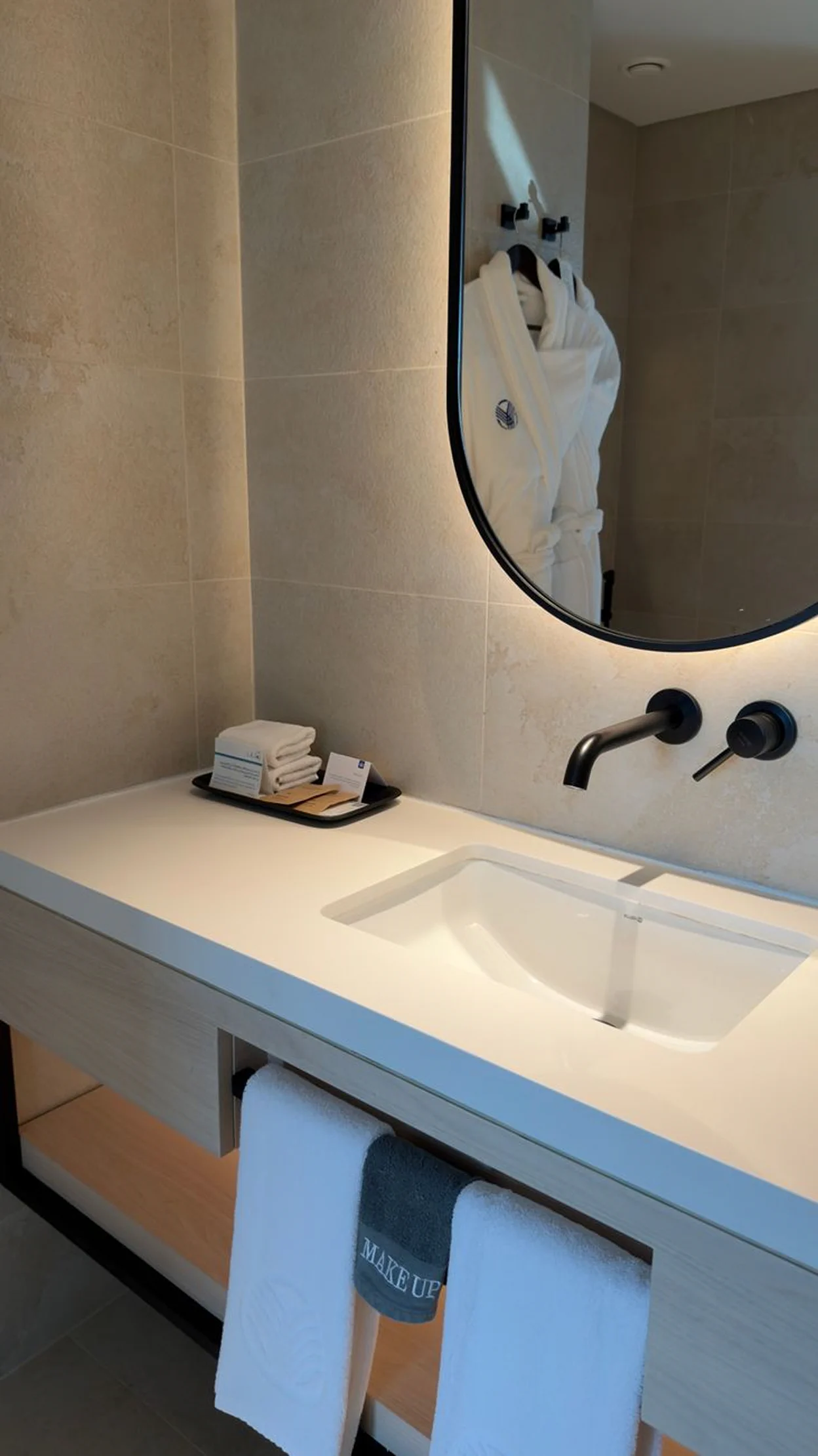 Bathroom vanity in the garden triple room with a modern sink, mirror, and clean towels.