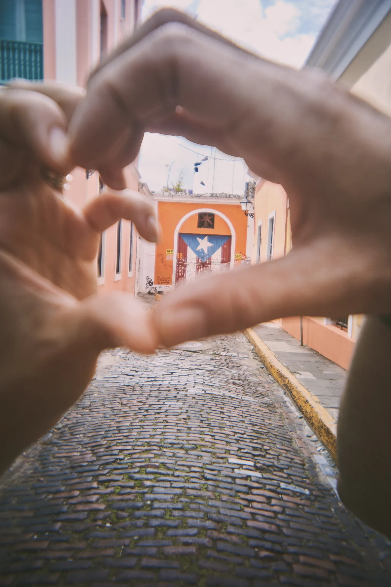 hands framing a puerto rican flag mural — lifestyle photography by Tom Kubik