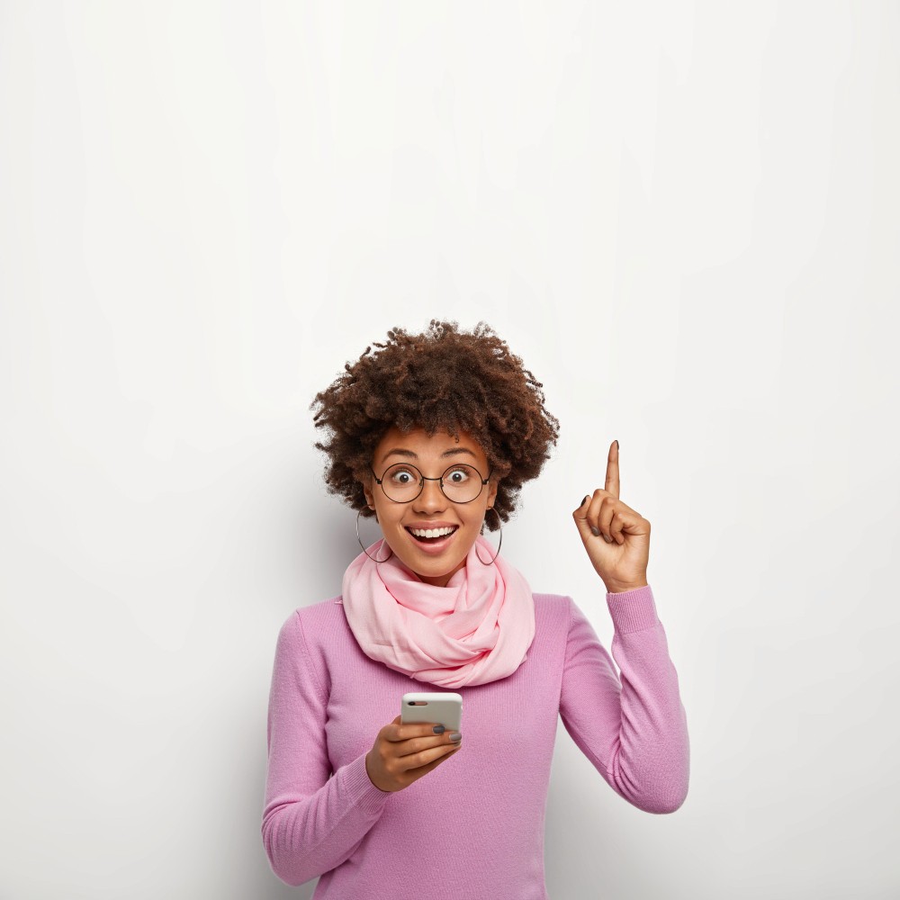 Woman working on a laptop computer at a table in a bright room.