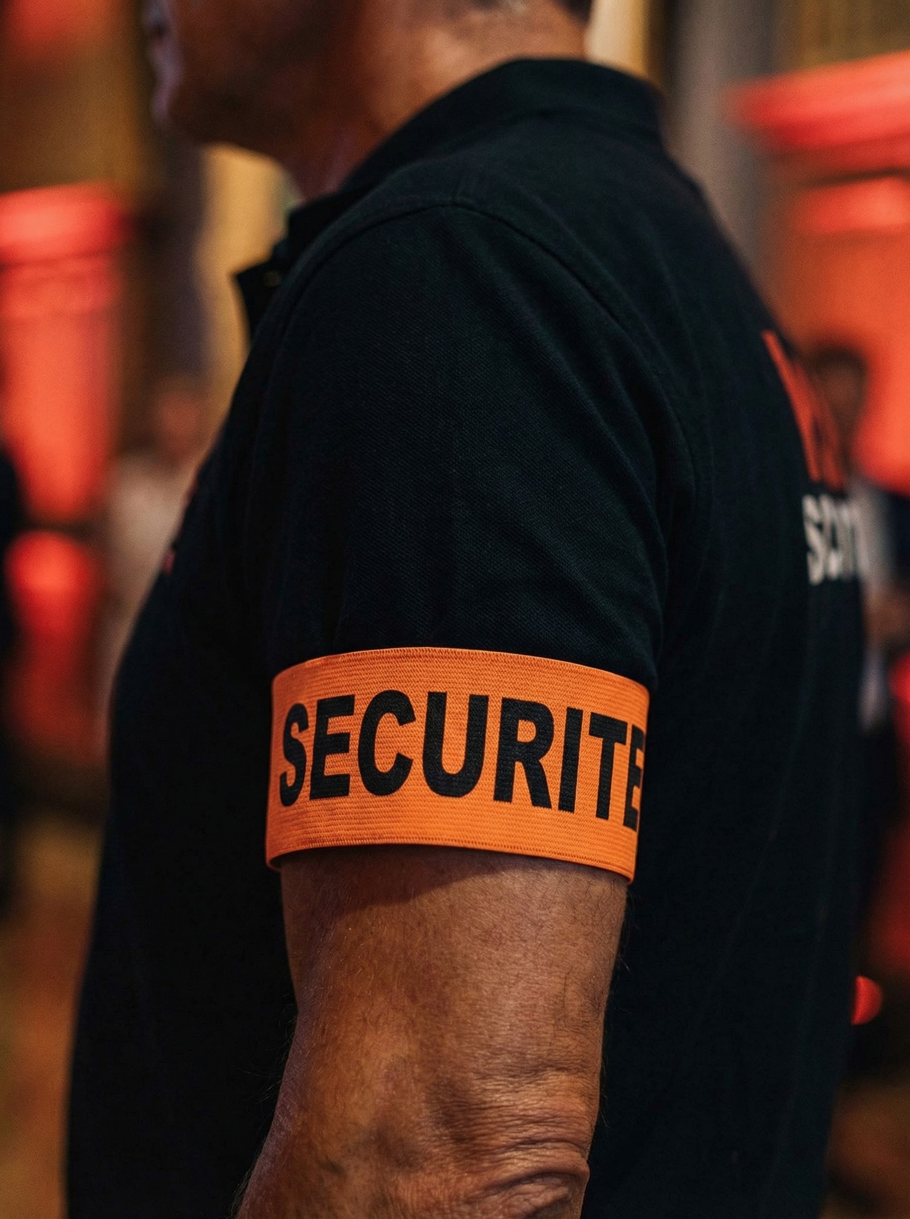 Agent KRK Security en mission de gardiennage dans un bâtiment à Genève, Salle du Faubourg, focus sur le brassard orange Sécurité