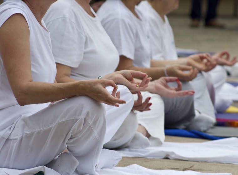 People seated together in white cotton clothing