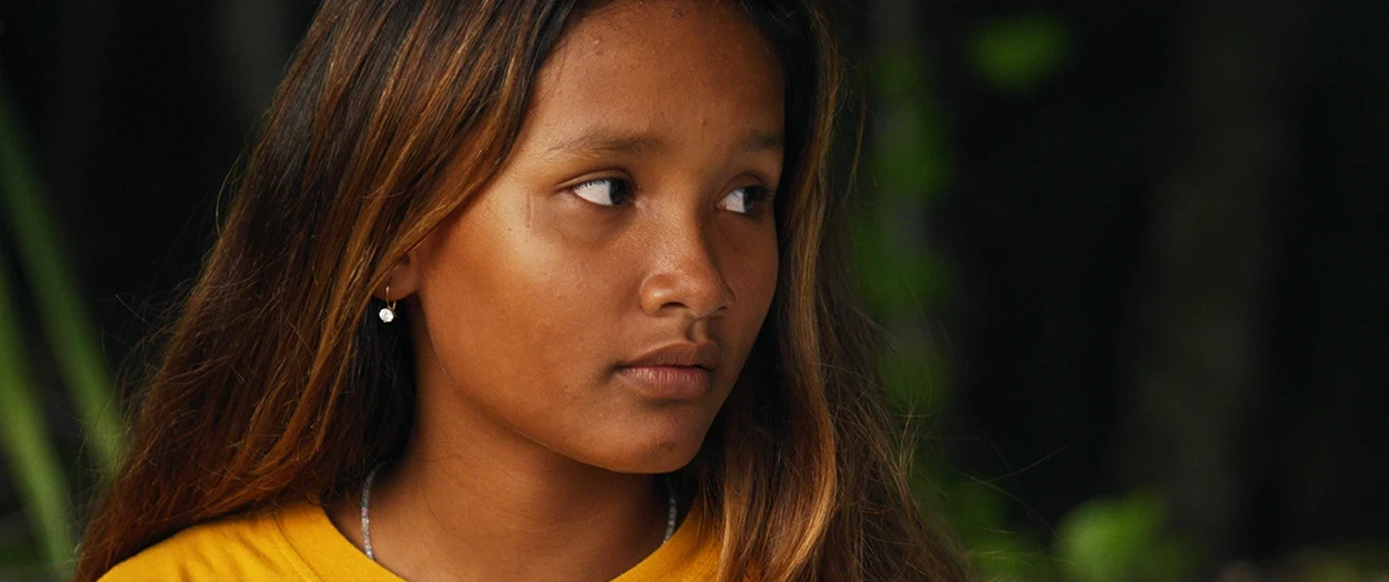 Indonesian girl sitting in the jungle looking to the left