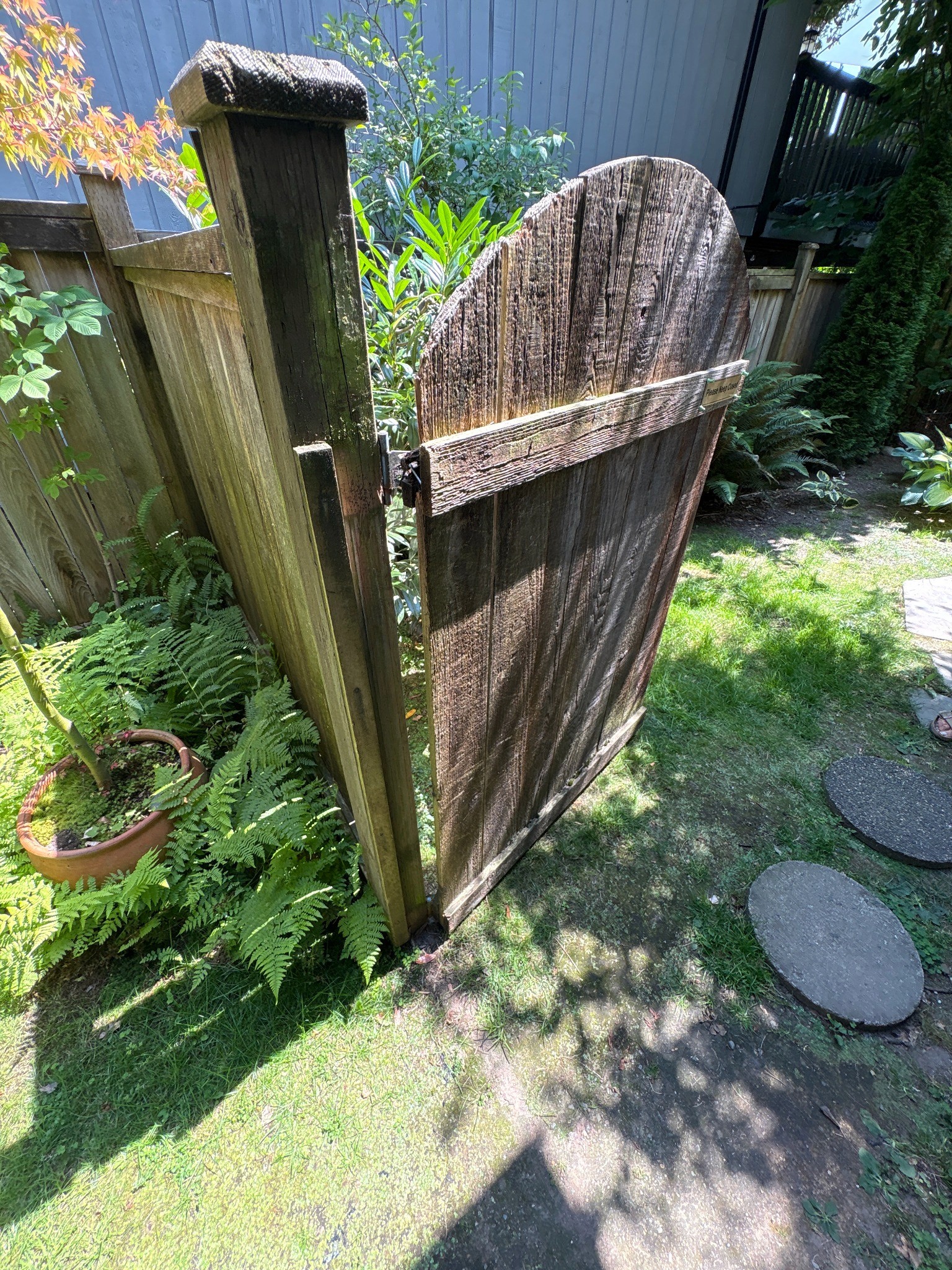 Existing exterior privacy gate before repair and adjustment.