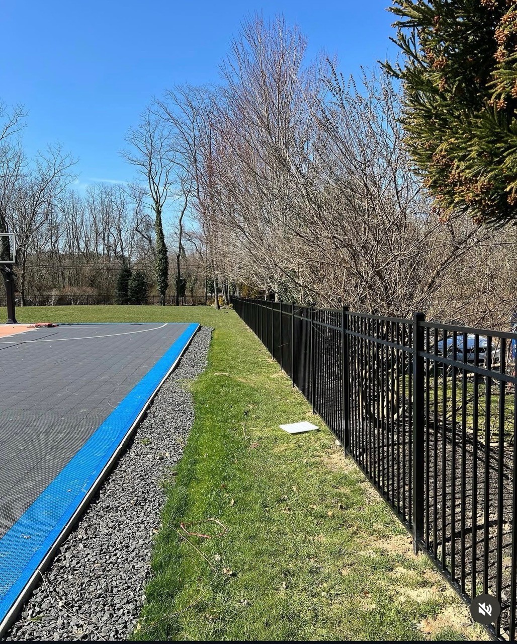 Black aluminum fence along a lawn by Bonilla Irrigation & Contracting, Long Island NY