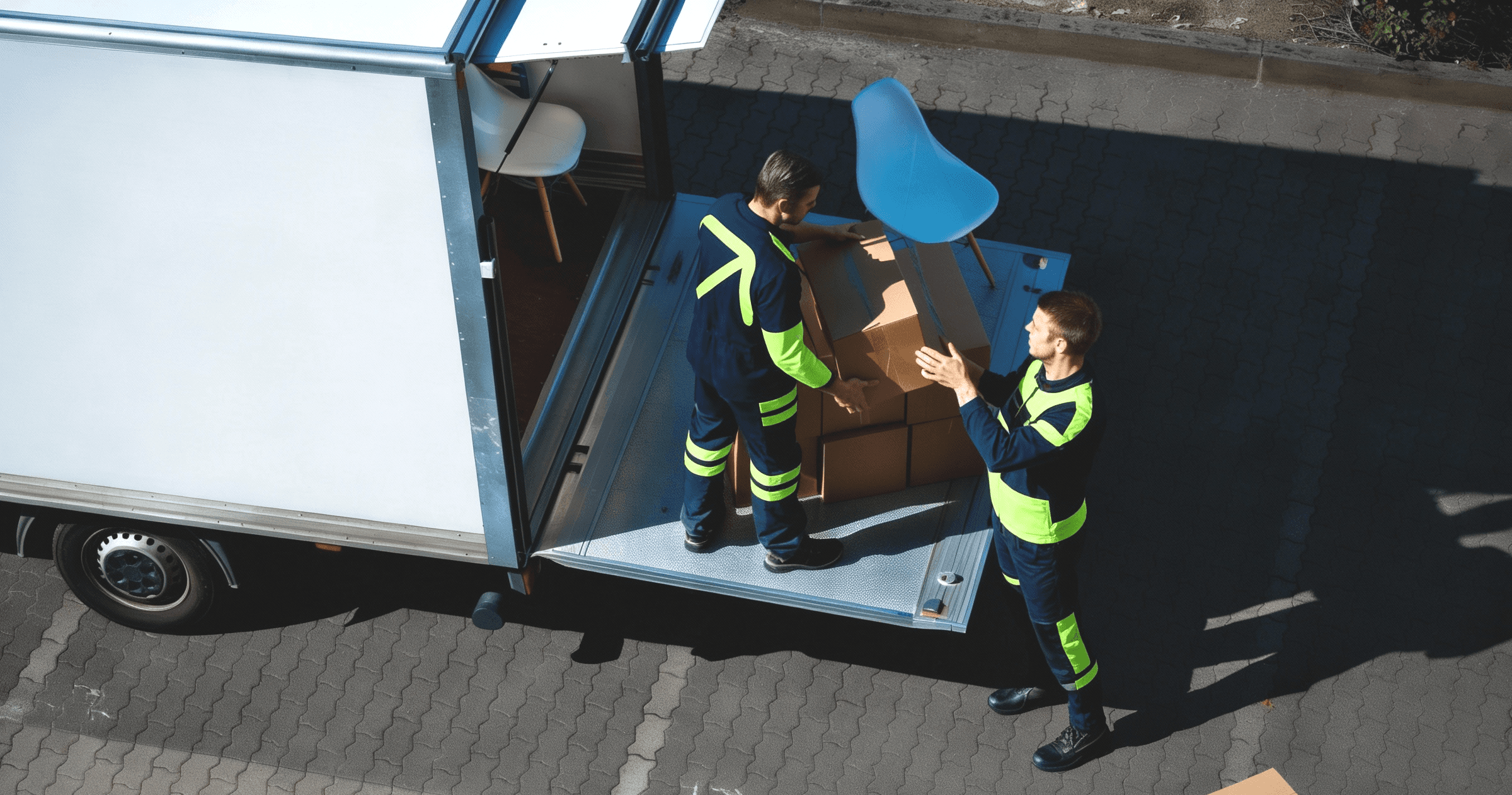 Two Moving Company workers holding boxes and smiling.