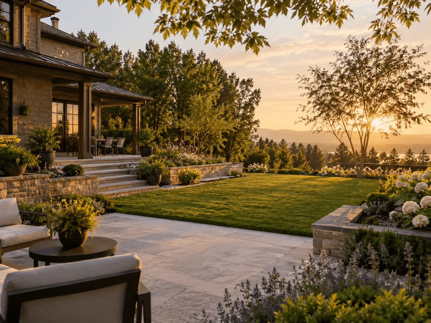 Patio with lounge chairs overlooking a lawn and trees at sunset