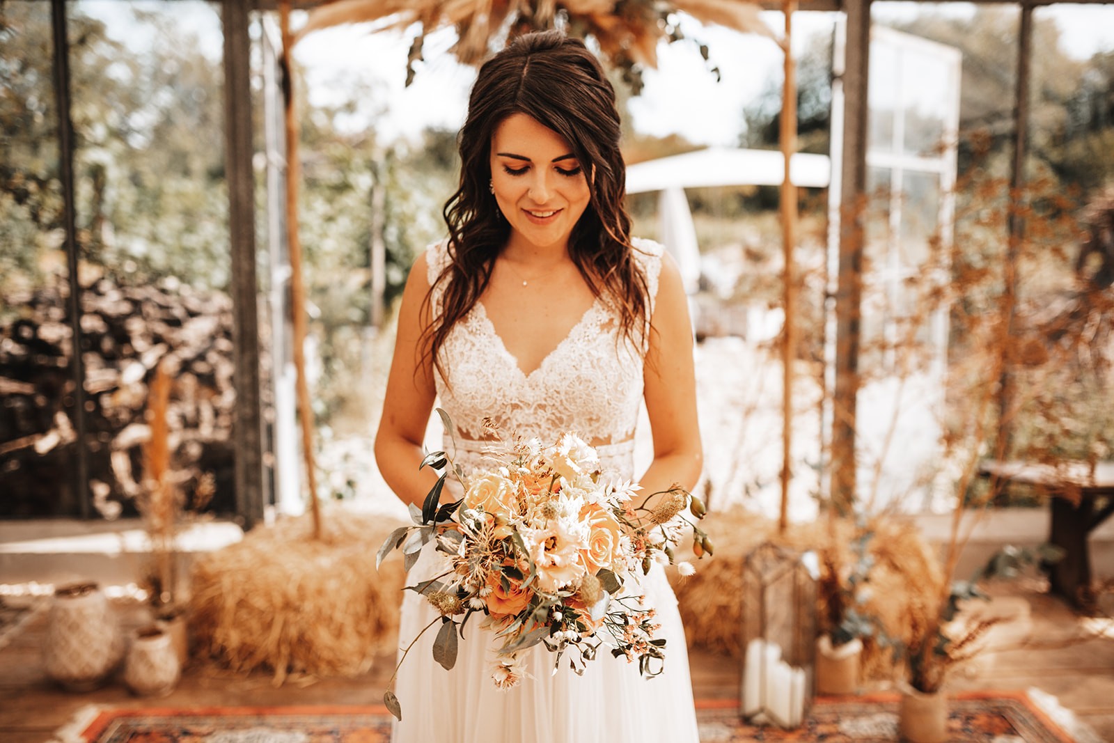 Boho-Braut in einem fließenden, langen Brautkleid zwischen Obstbäumen und Blumenwiesen im Genussgarten Bingen, umgeben von natürlicher Schönheit.