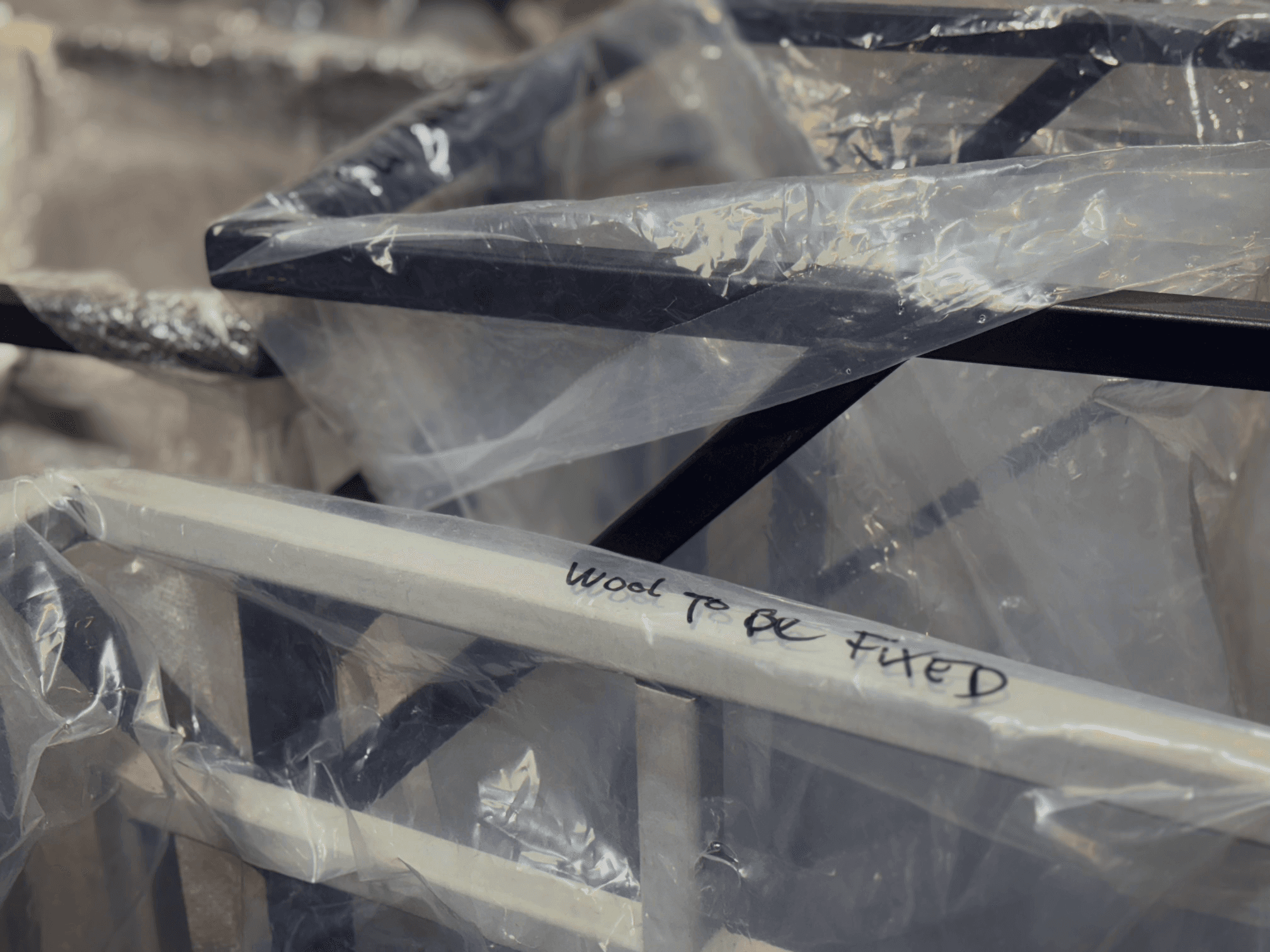 Metal frames wrapped in plastic, one marked "Wool to be fixed."
