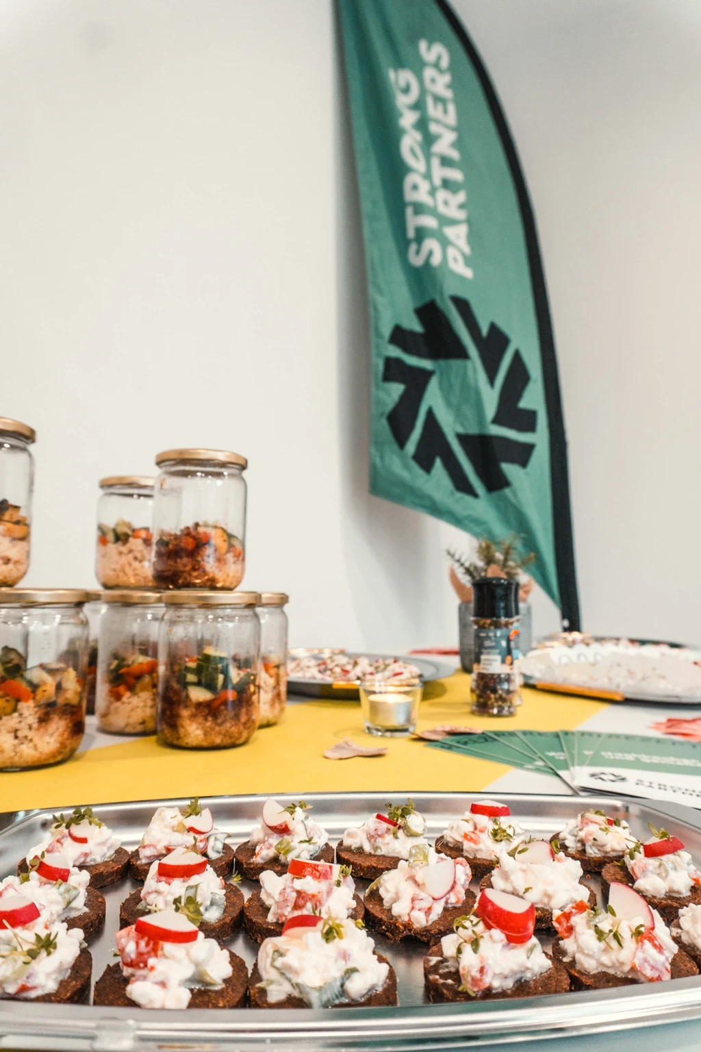 Ein Meal-Prep-Buffet auf einem Tisch, im Hintergrund eine Strong Partners Flagge