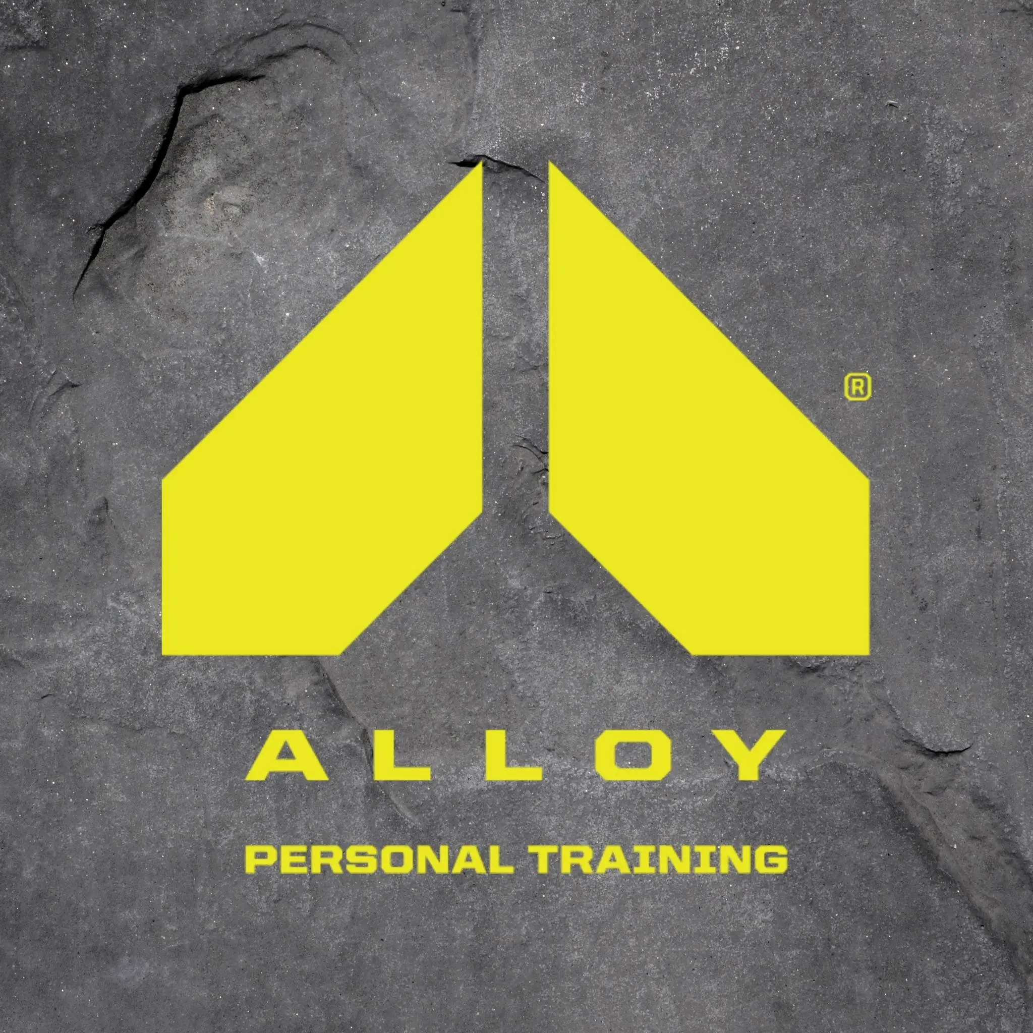 A modern logo for Alloy Personal Training featuring a distinct yellow geometric design on a textured gray background, highlighting personal fitness services in Bradenton, FL.