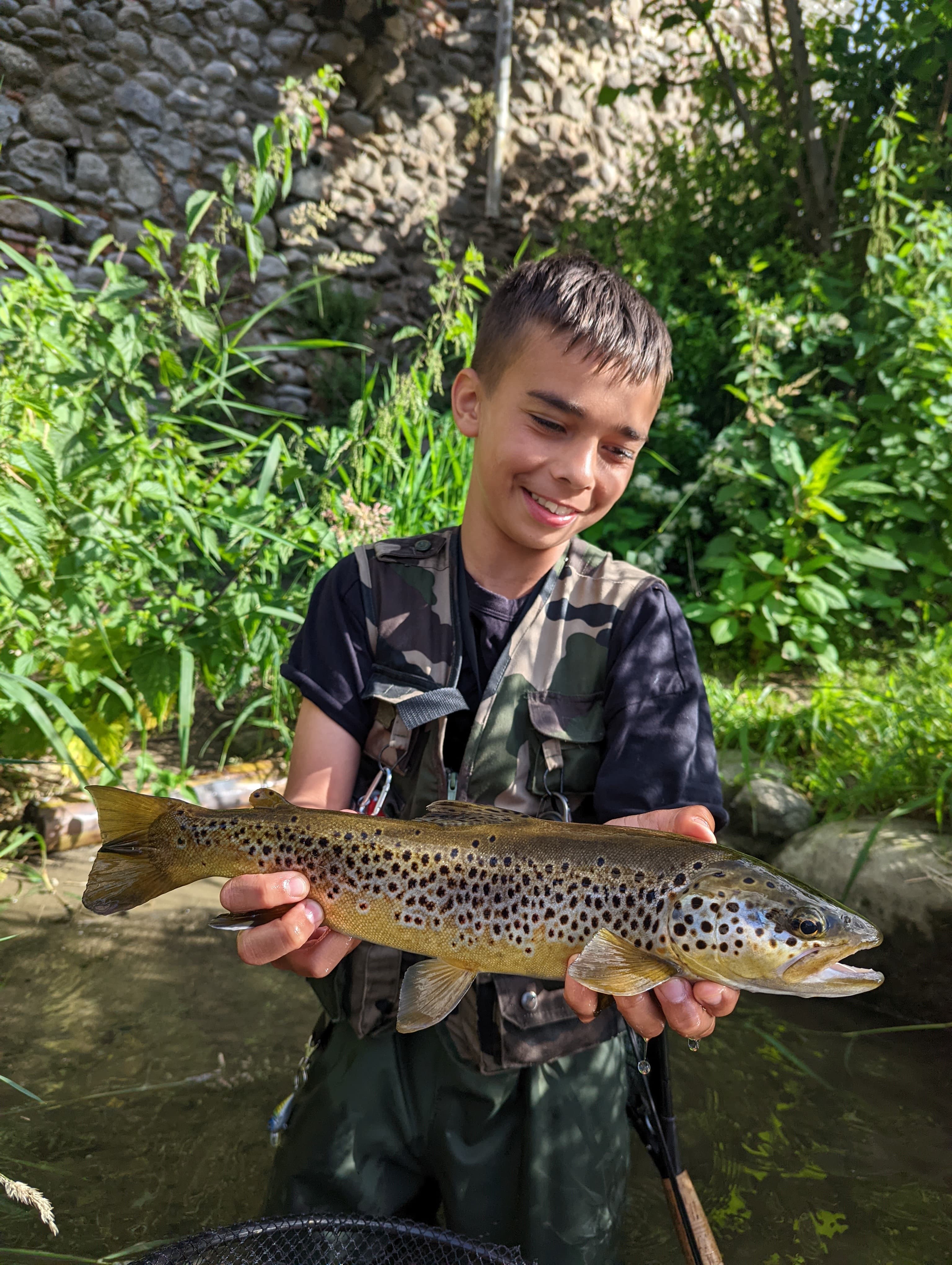 Fly fishing Ariège: calm mountain waters reflecting the green Pyrenees.