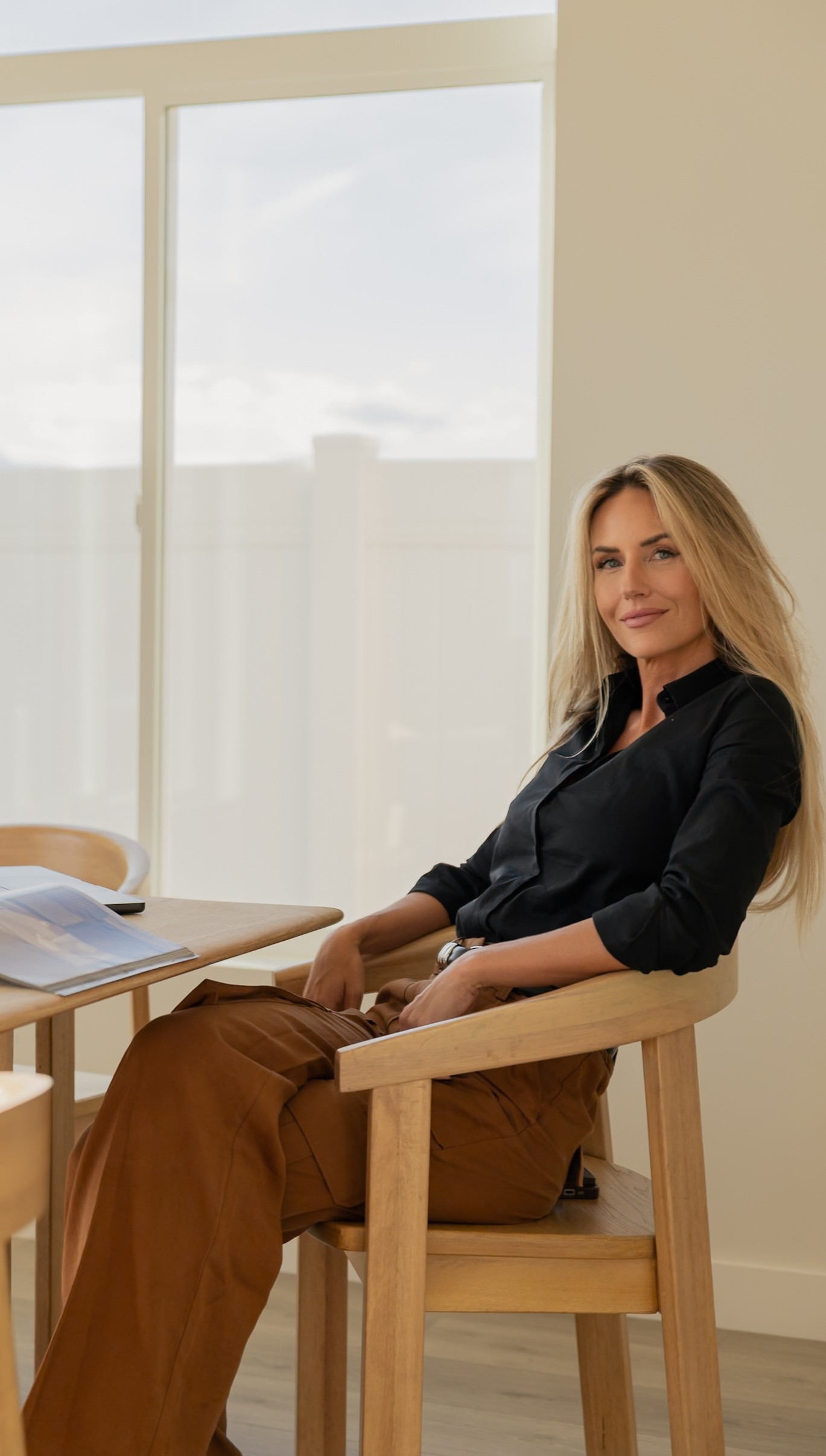 Portrait of a laughing person with curly hair wearing a white shirt