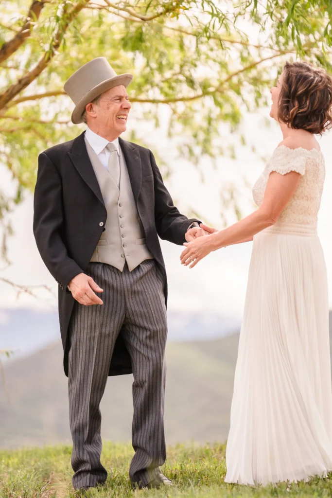 Newlyweds holding hands in a sunlit field