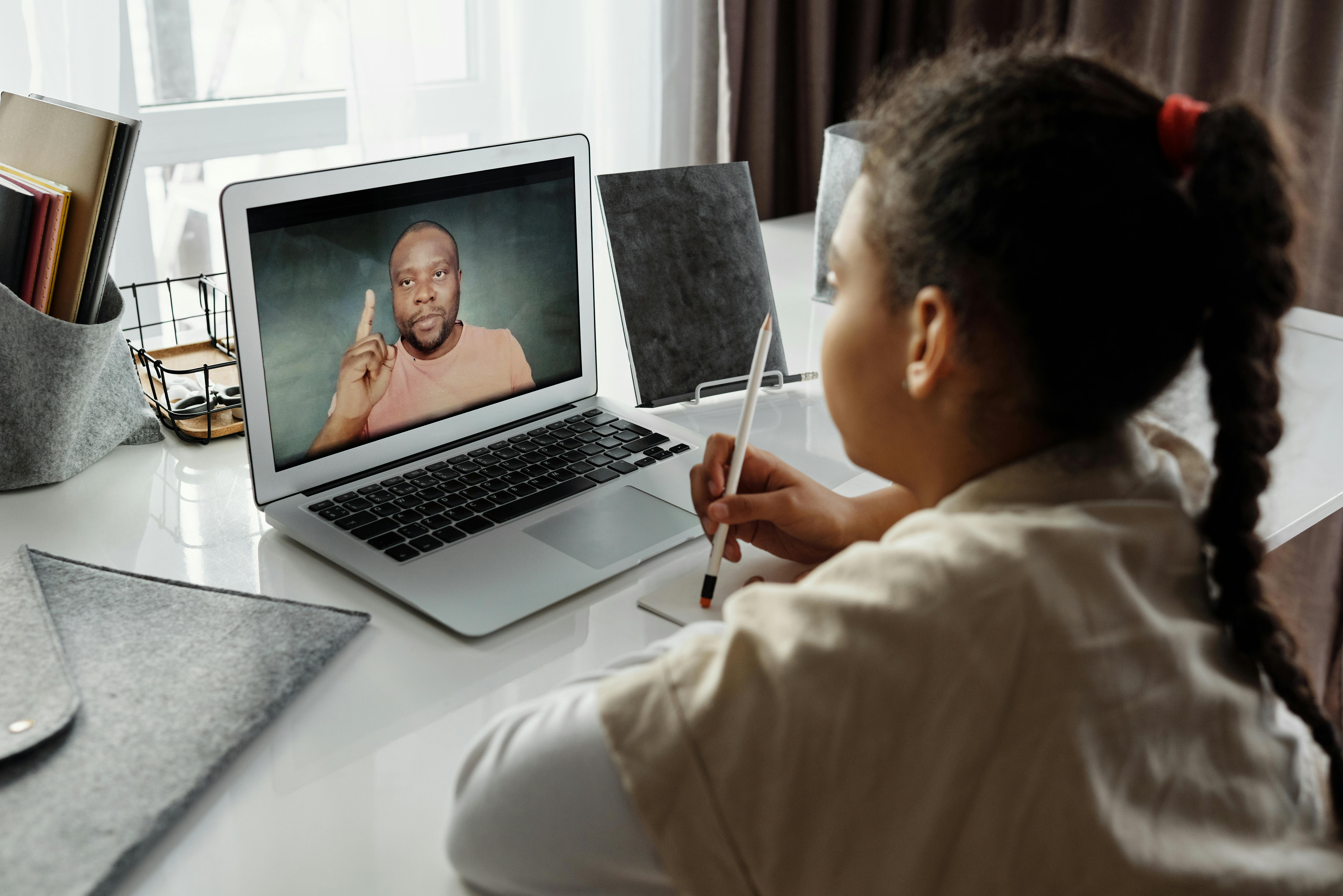 woman sits on sofa while using laptop computer