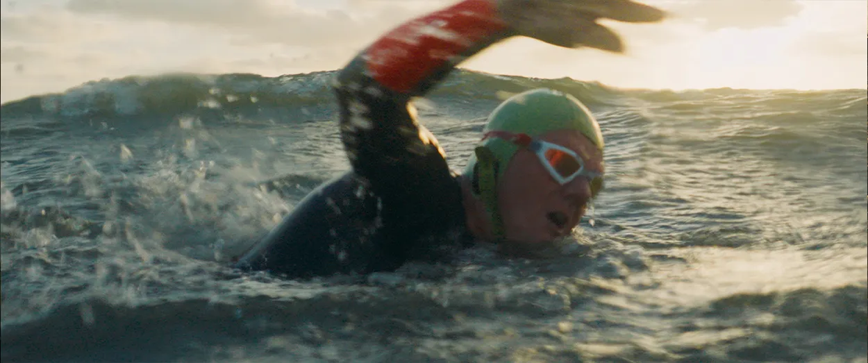 Swimmer in open ocean gasping for air while doing front crawl