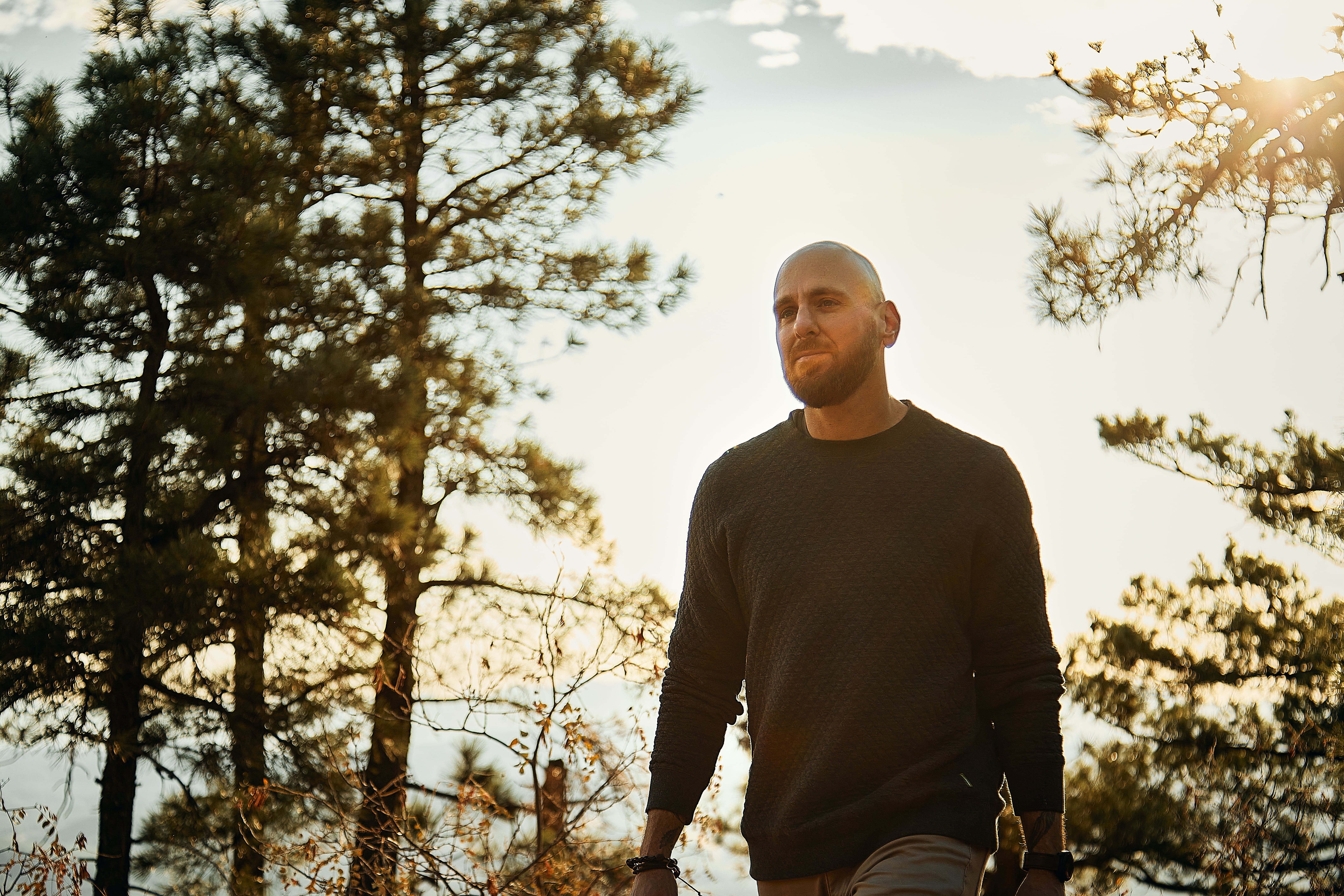 bald man walking through woods