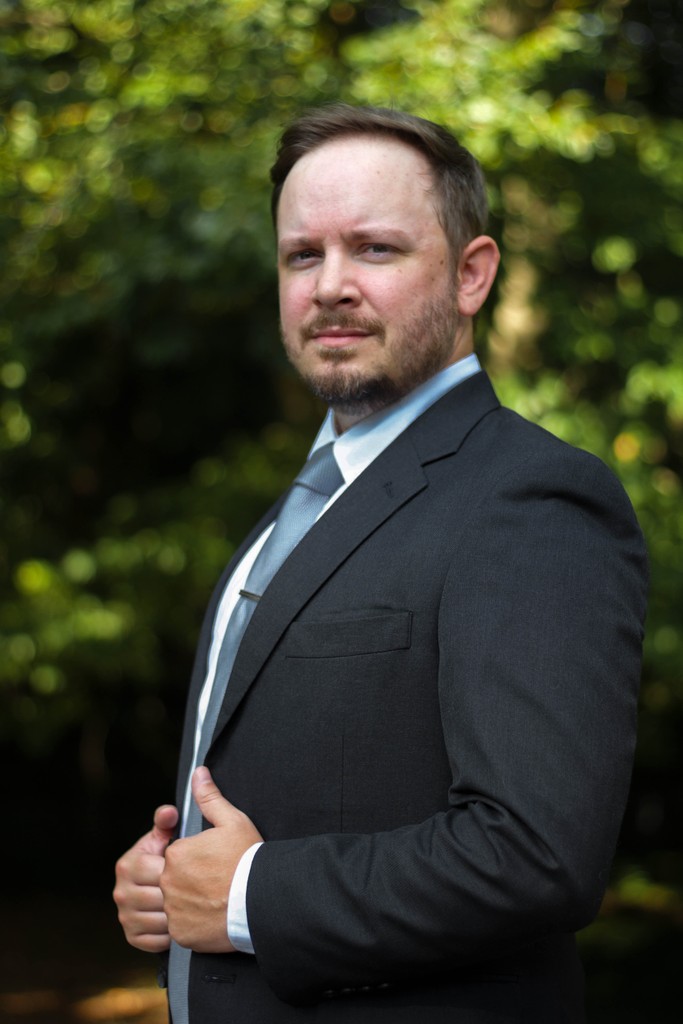 man wearing black notched lapel suit jacket in focus photography
