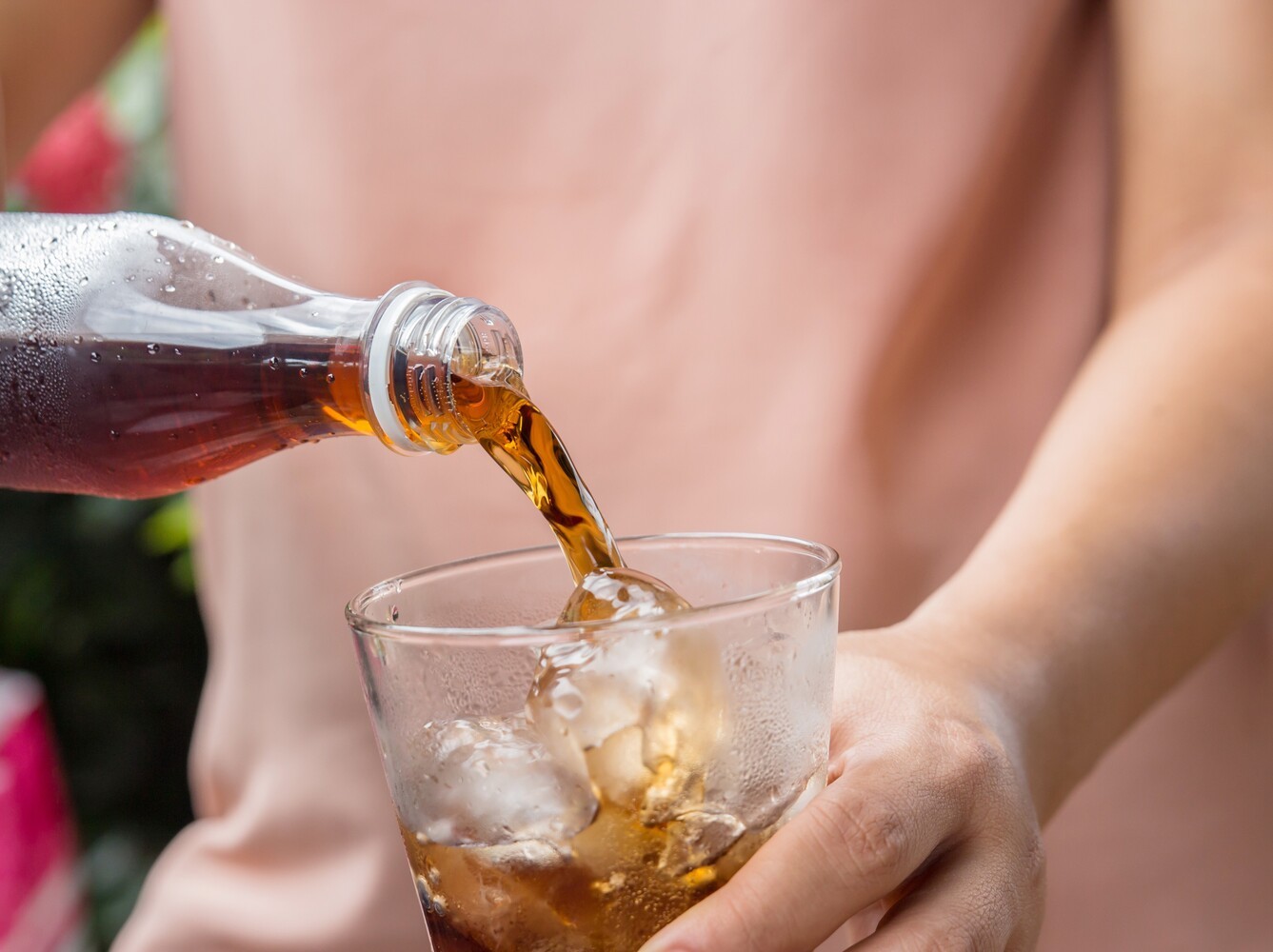 person pouring a sugary drink, which slows their progress in trying to lose weight without exercising
