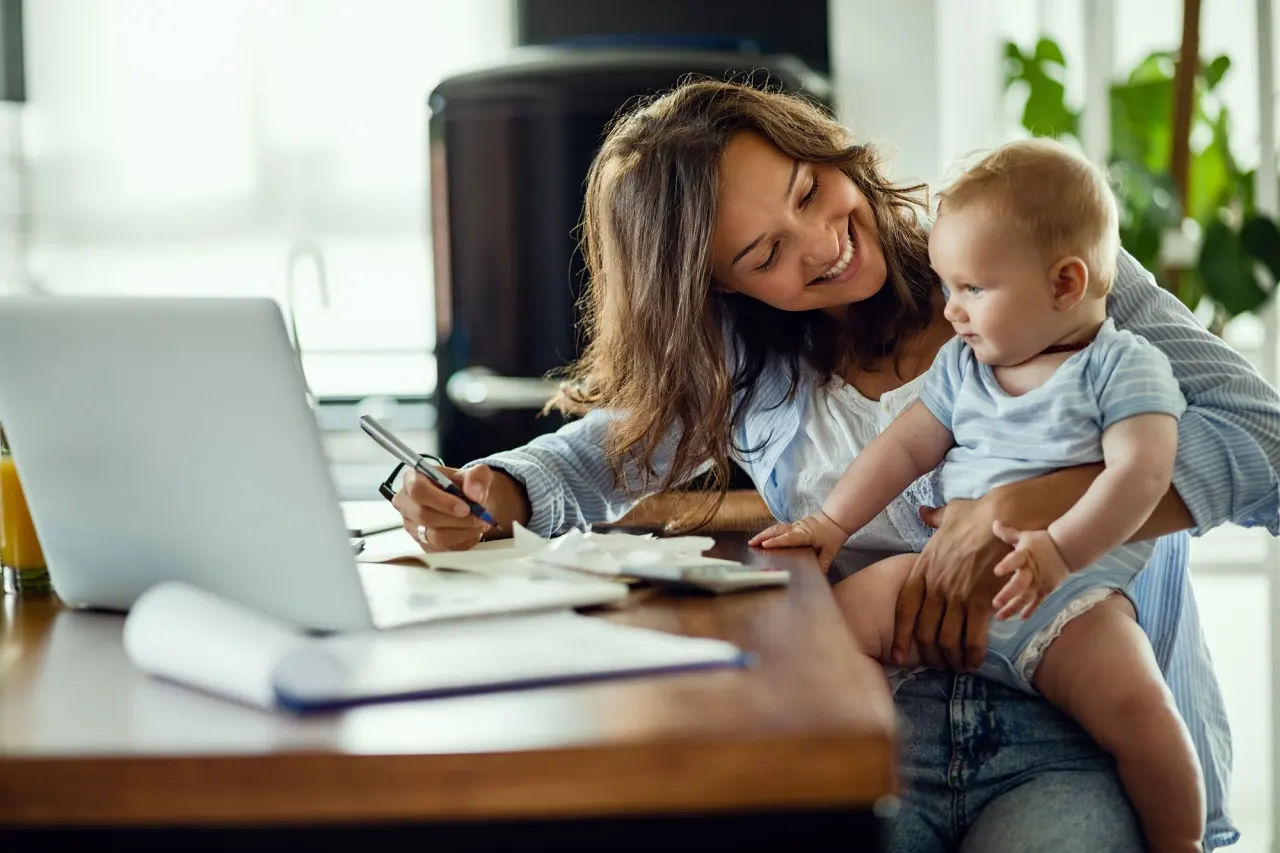 Madre sonriendo con su bebé en brazos, representativa de la protección financiera familiar y la tranquilidad que garantiza el seguro de vida riesgo de Allianz en Murcia centro.