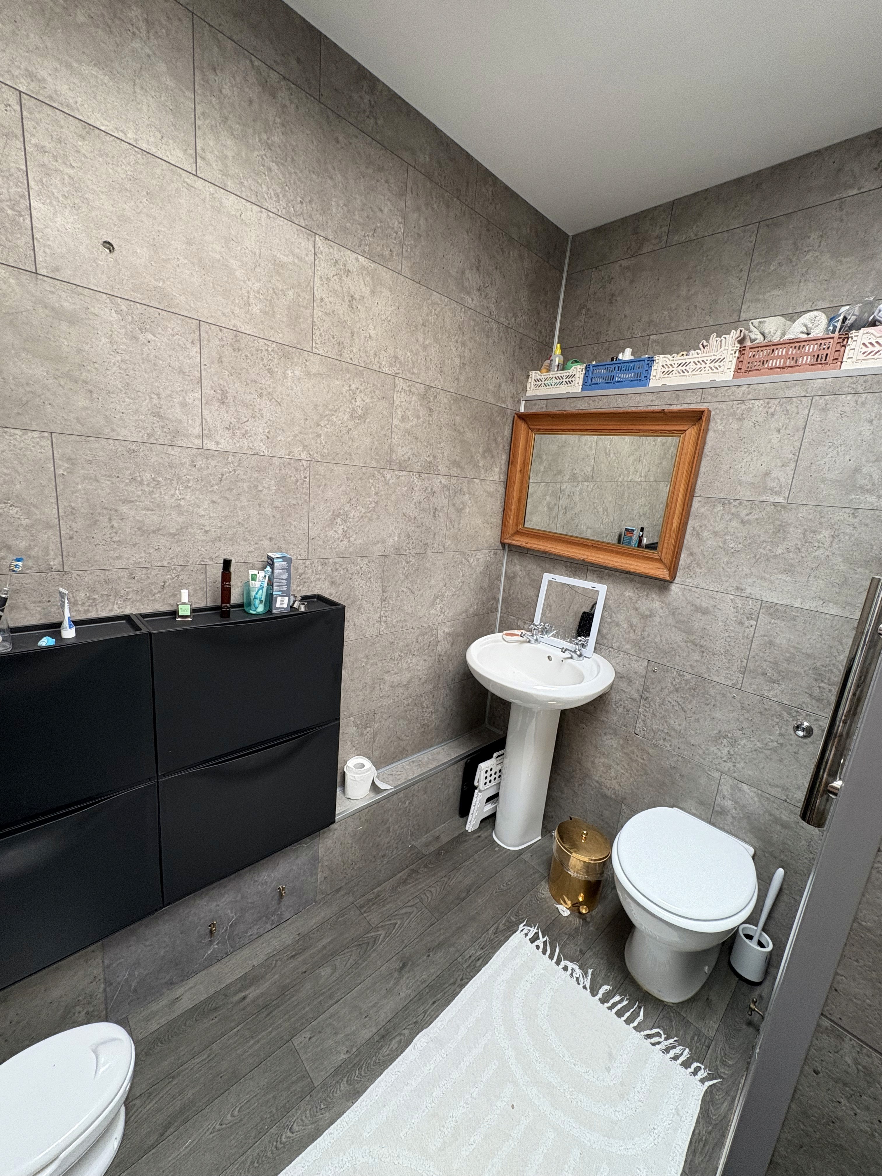 Before: small bathroom with dark tiles, basic fittings and limited light