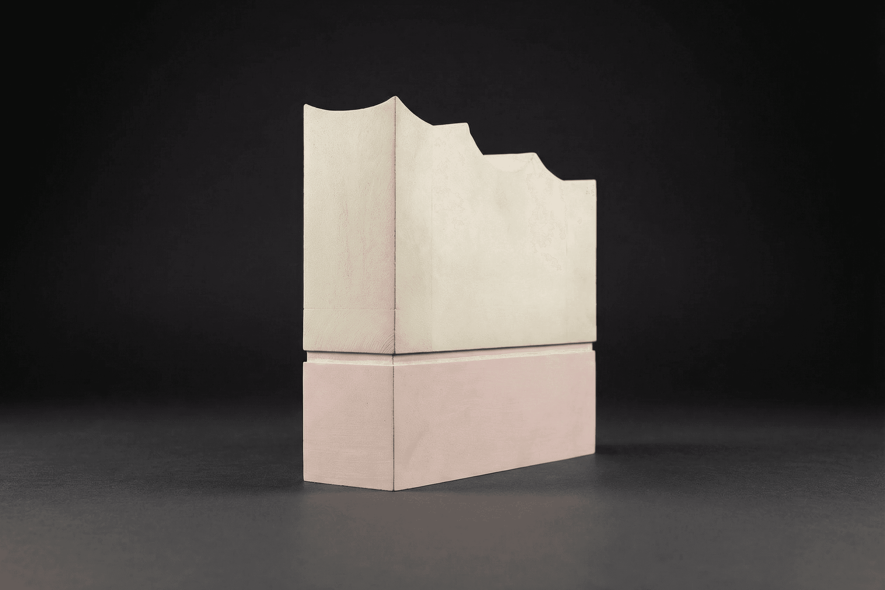 Two-tiered sculpture with scalloped top edge