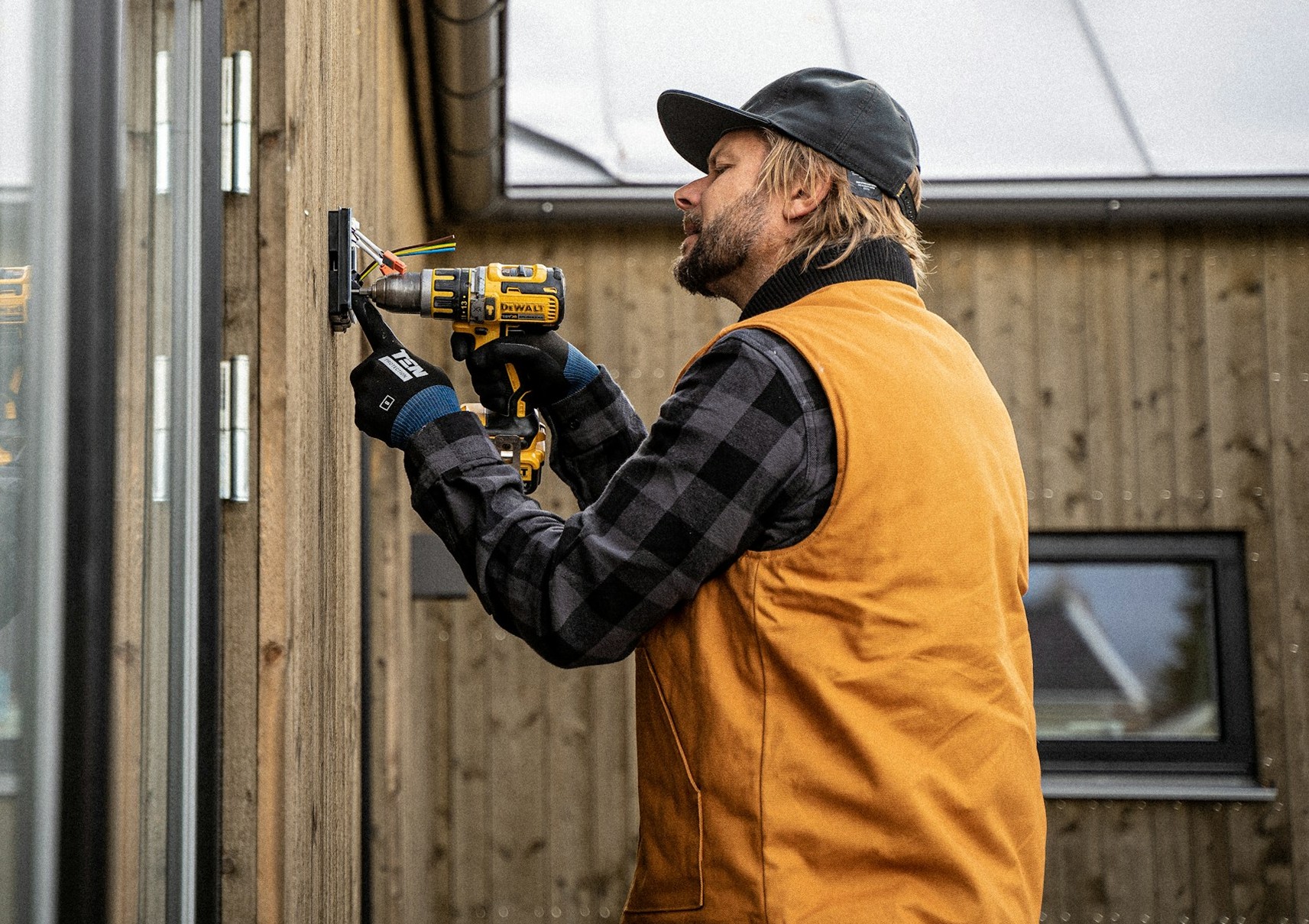 A electrician drilling a hole to pass a wire