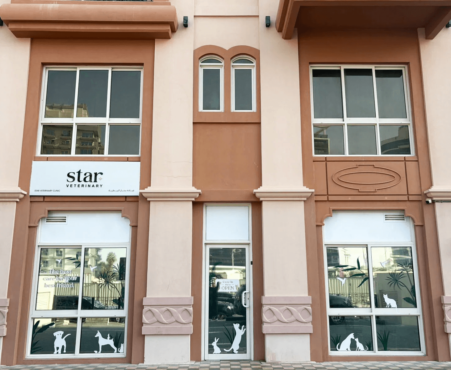 The front of Noble Veterinary Clinic in DIP, Dubai. Our vet clinic features glass doors and windows with reverse silhouettes of pets on the windows surrounding the doors.