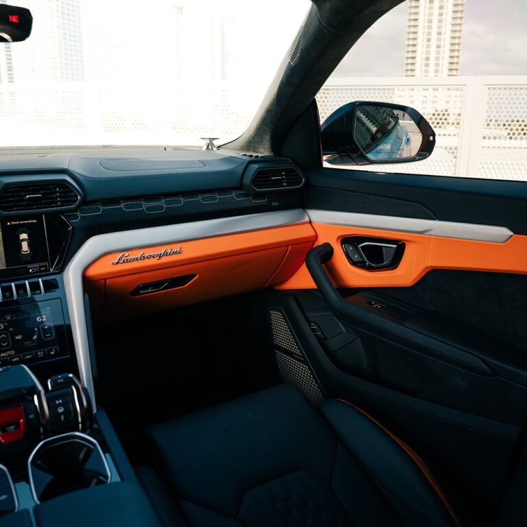 Dashboard view Lamborghini Urus S, orange interior details, advanced infotainment system.