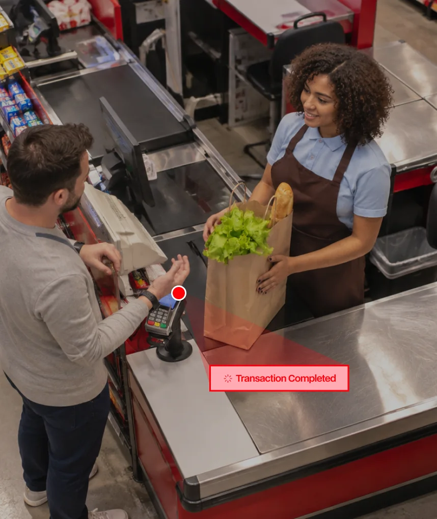 Overhead view of a cashier serving a customer, with the transaction marked complete