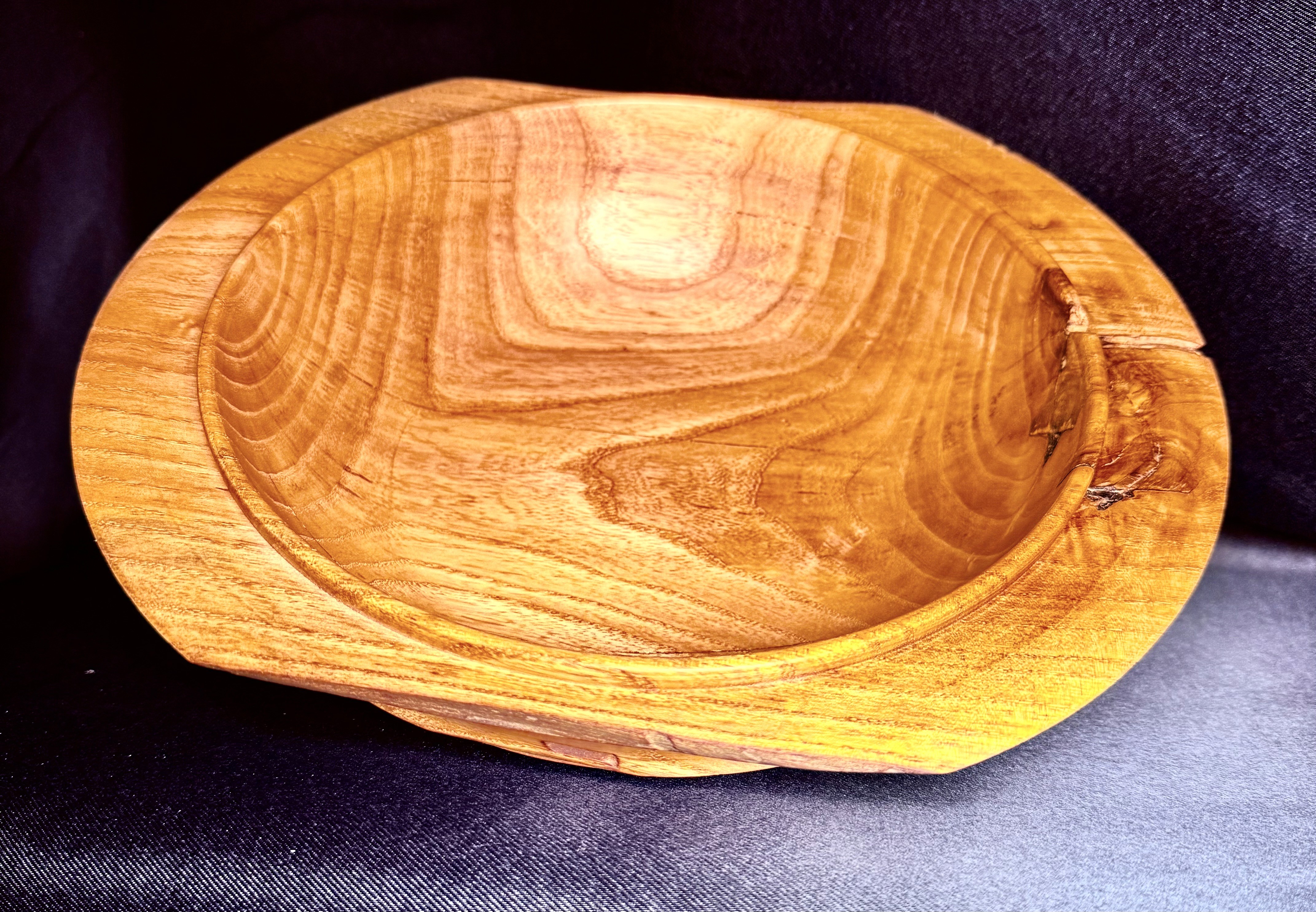Hand-turned asymmetric live-edge ash bowl with a deep profile.