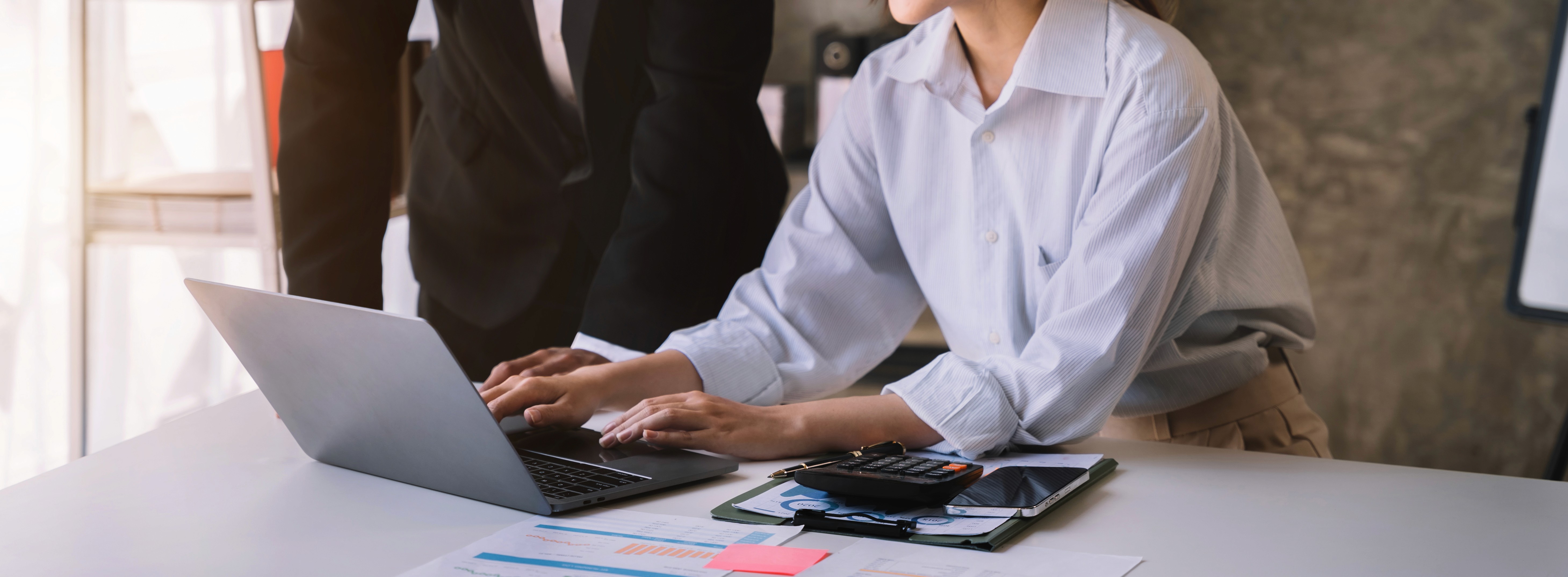 a group of people sitting around a table with laptops