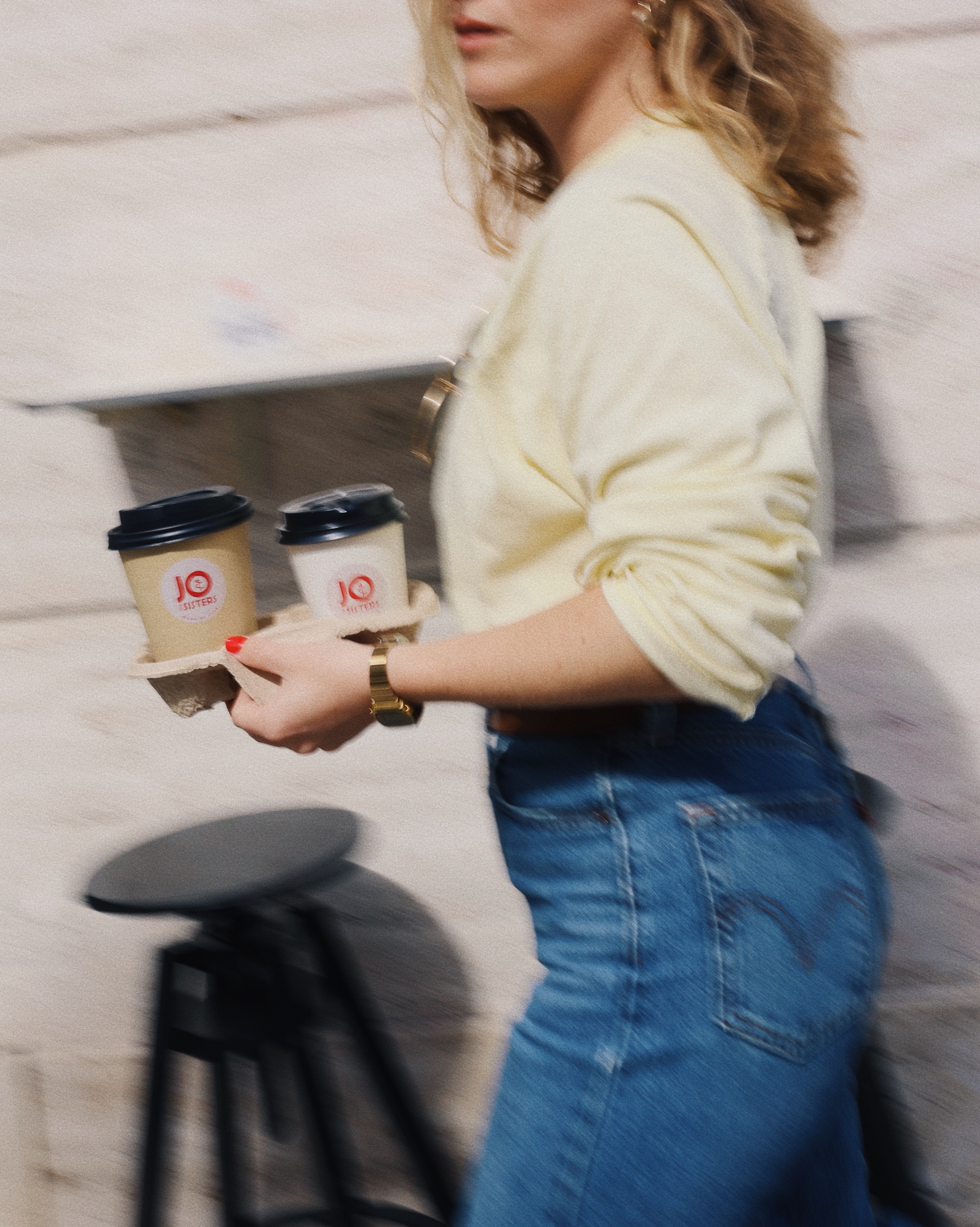 Woman is taking Jo & The Sisters coffee cups on the go