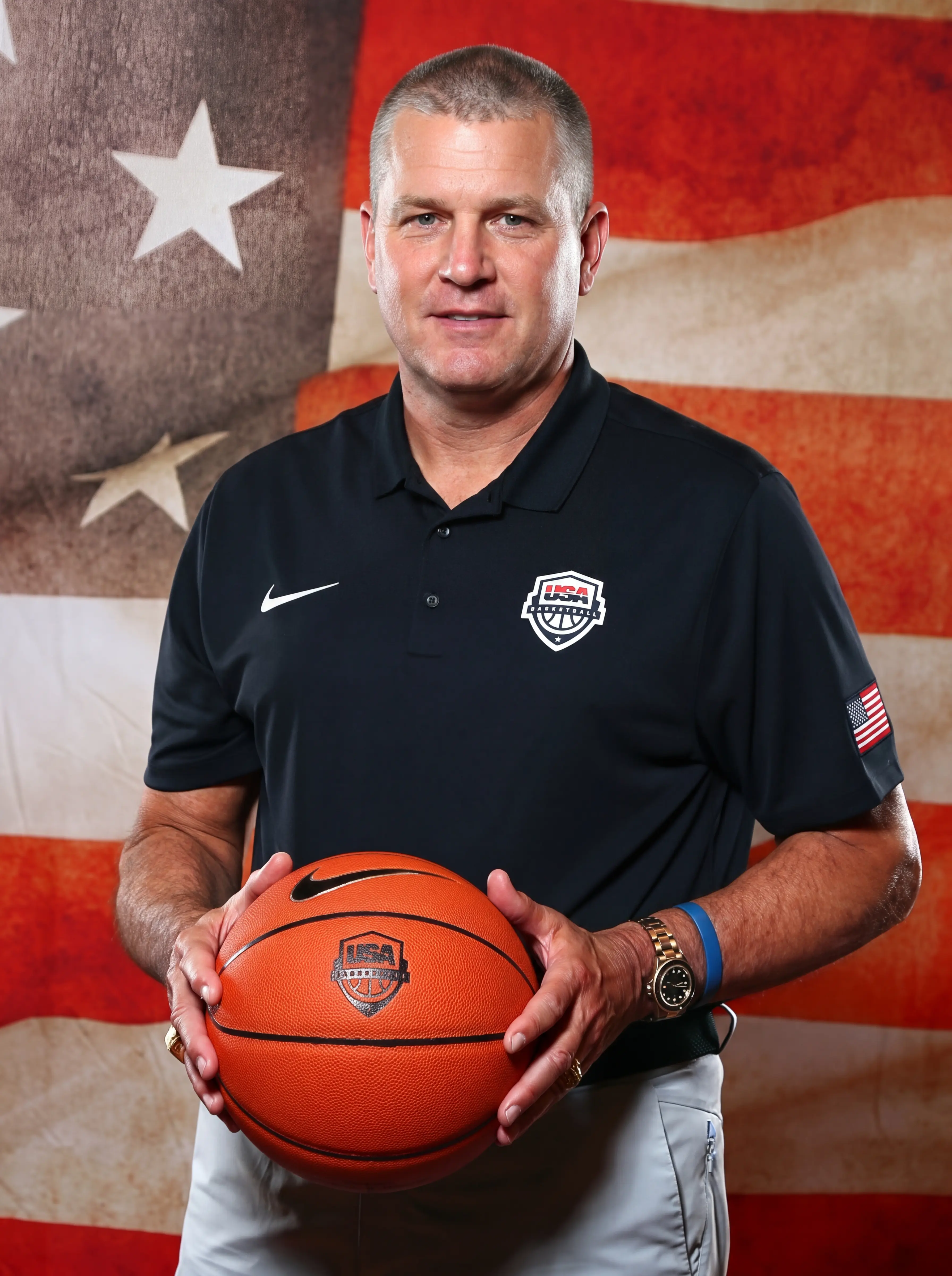 Portrait photo of a sports coach infront of USA Flag