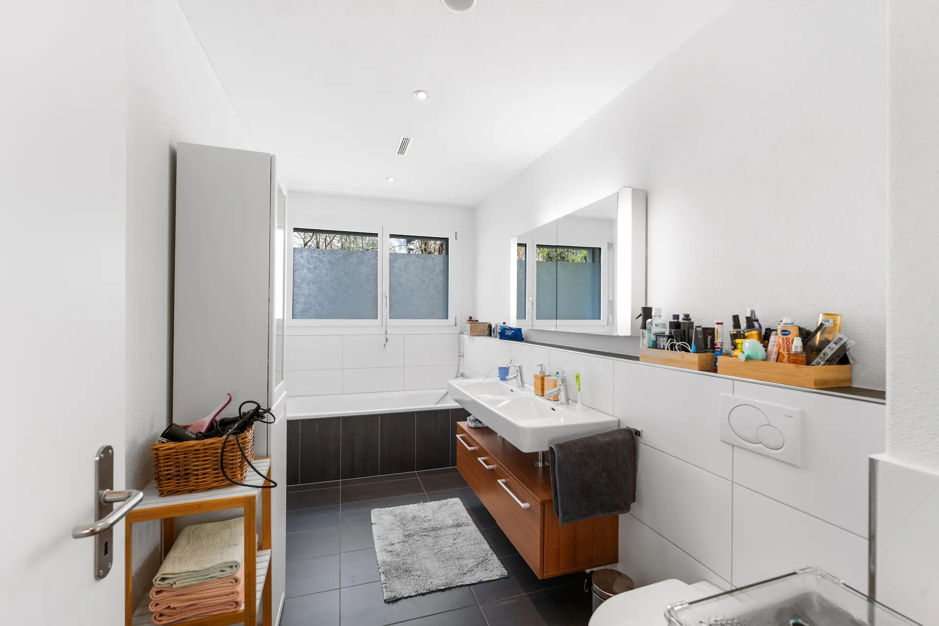 Helles Badezimmer mit Badewanne, Tageslicht und grosszügigen Ablageflächen