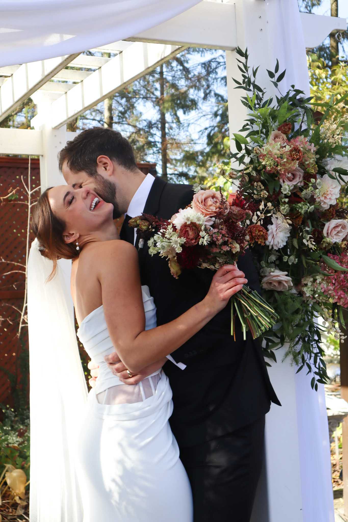 Bride and groom celebrating their marriage with autumn flowers and smiles