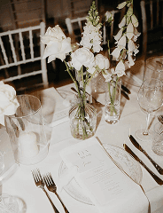 Elegante Tischdekoration mit Menükarte und Blumenarrangement für eine Hochzeit in Essen