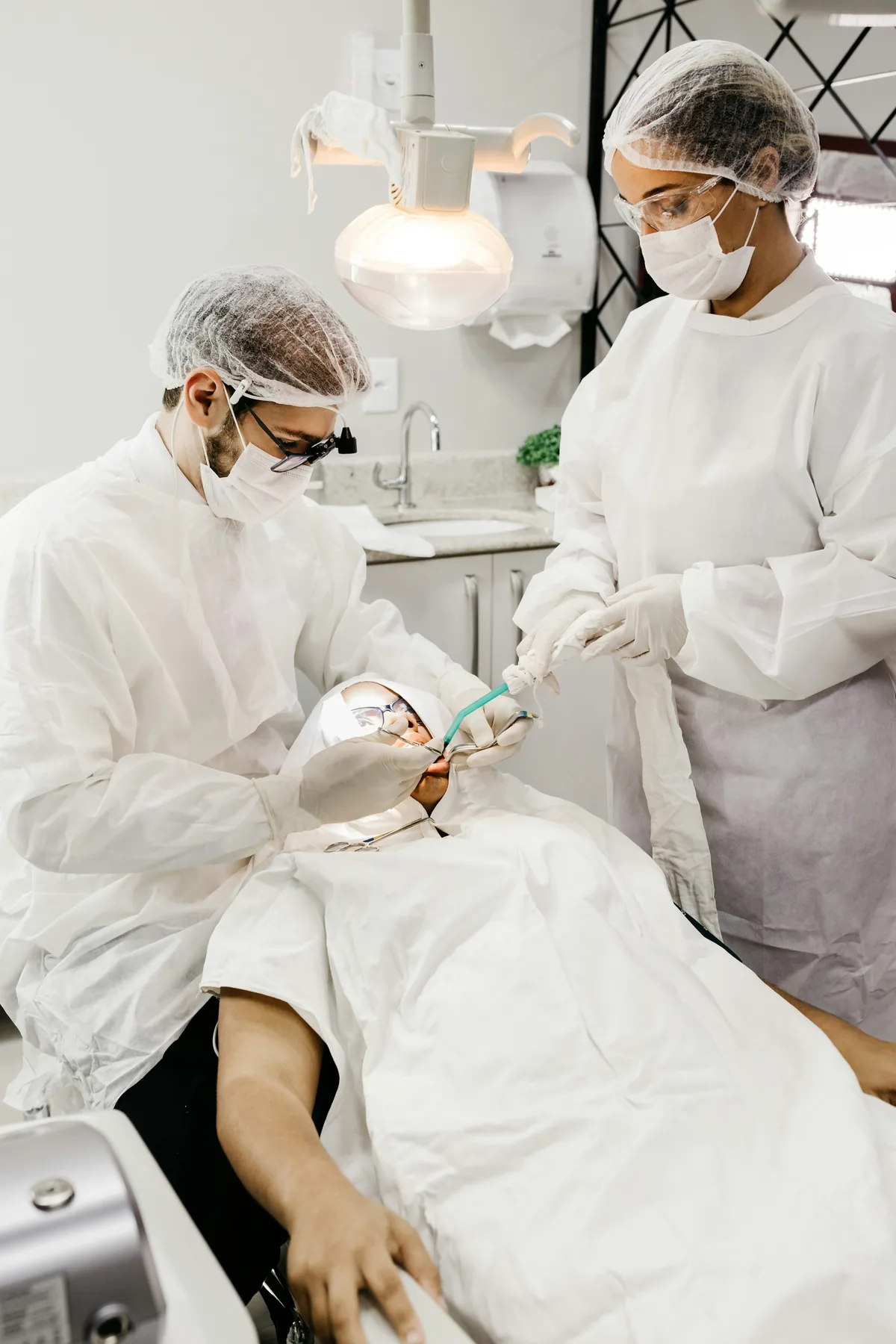 Dentist and assistant treating a patient in the dental chair