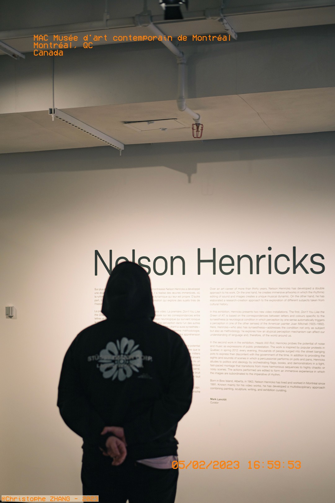 Personne en hoodie contemplant l'exposition Nelson Henricks au Musée d'art contemporain de Montréal.