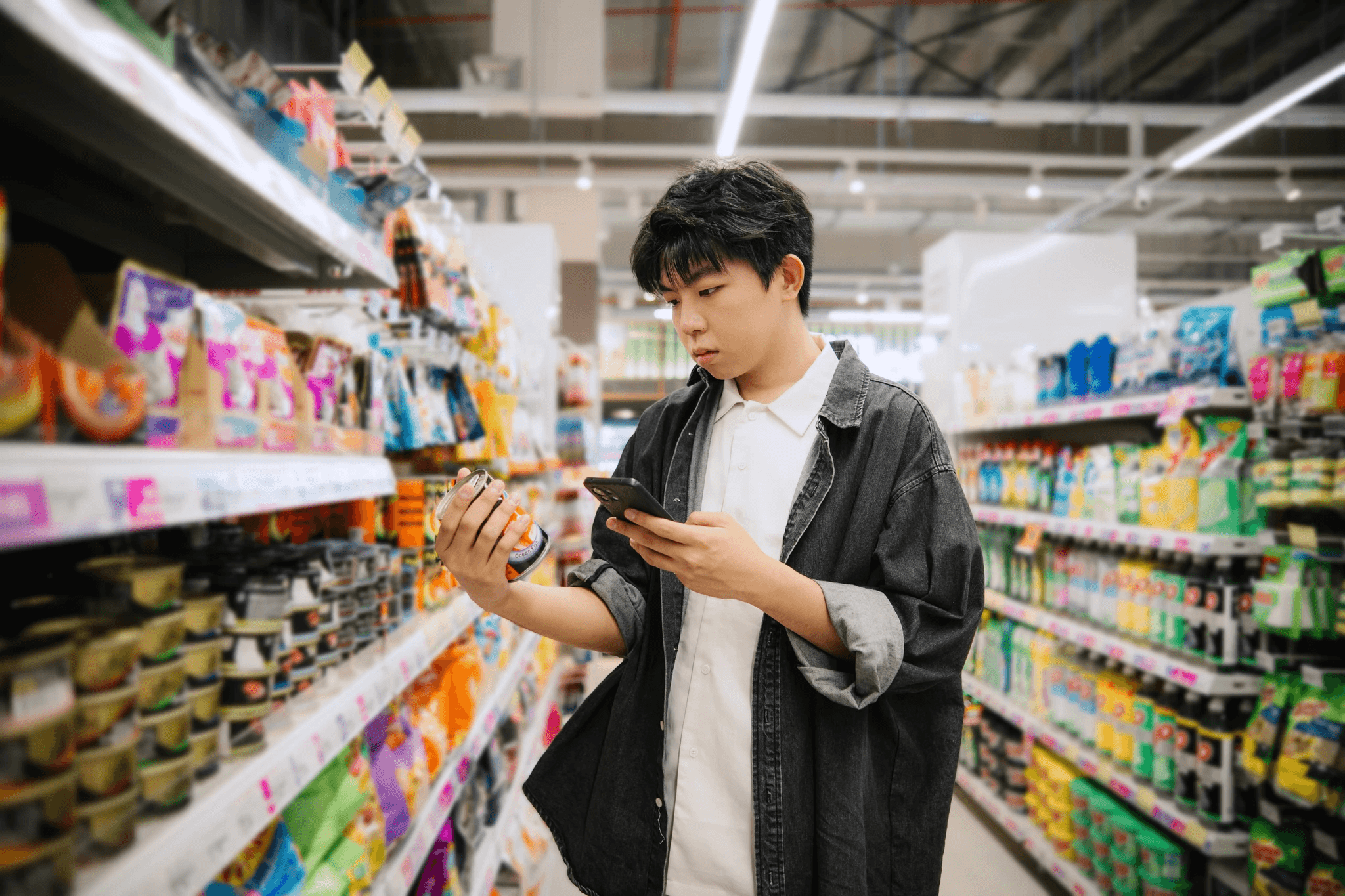 Shopper comparing products in a store while checking details on a smartphone