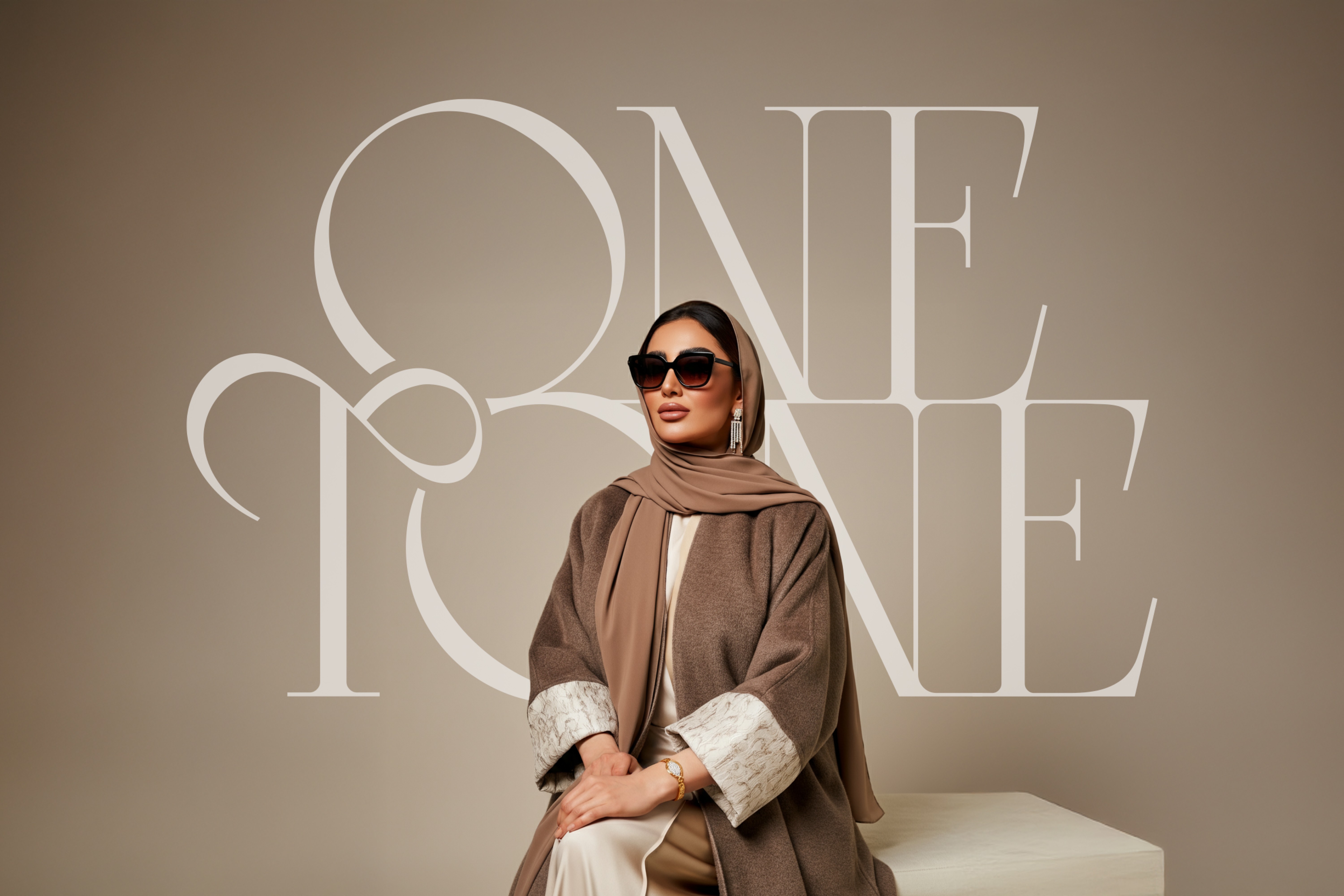 Luxury Abaya fashion branding – Onetone’s custom logotype displayed behind a stylish woman wearing an elegant beige Abaya and sunglasses, representing modern Middle Eastern fashion.