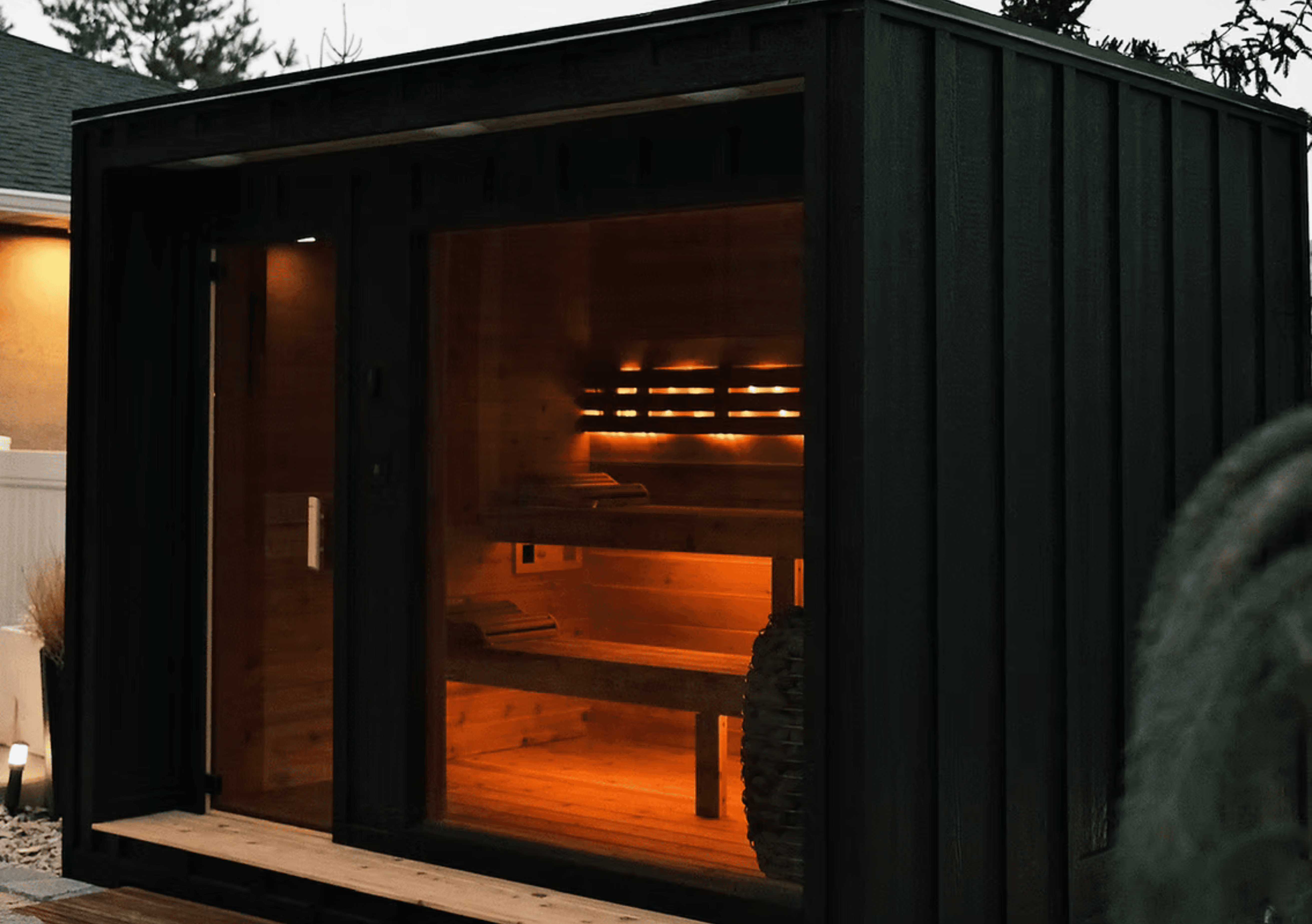 Aesthetic sauna at dusk with cool interior lighting.