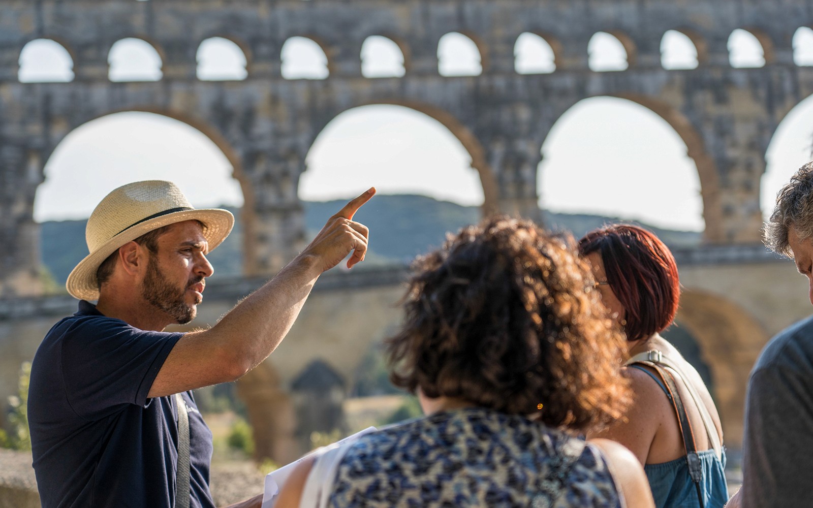 Tour guide explaining Pont du Gard to visitors in Provence.