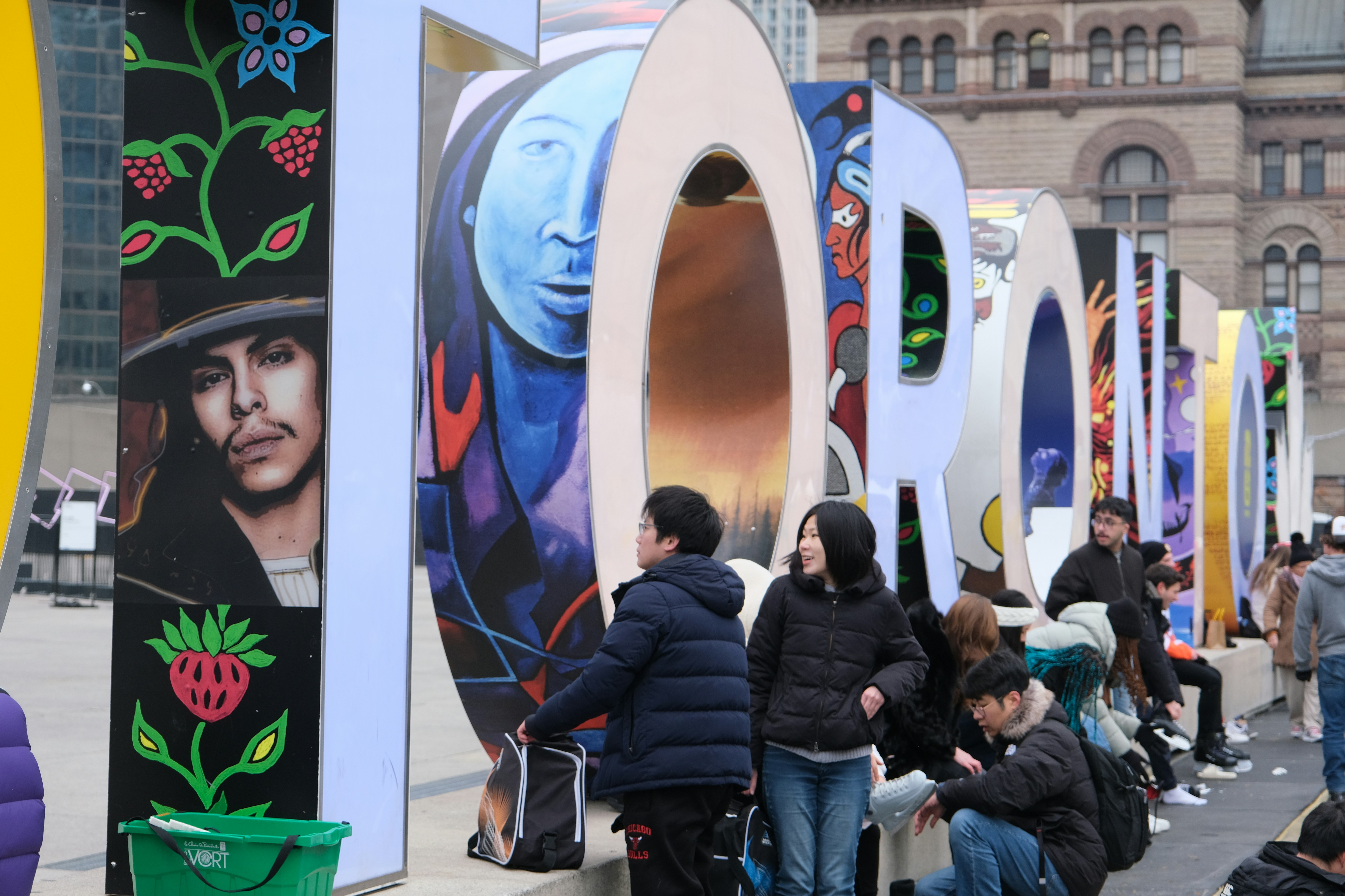 Large colorful art installation with people posing
