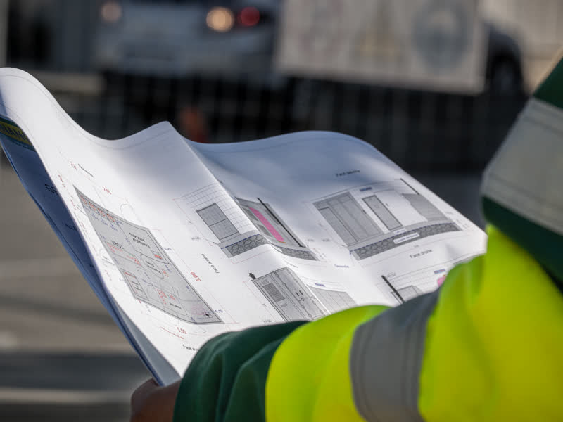 Technicien au téléphone devant une armoire électrique de chantier