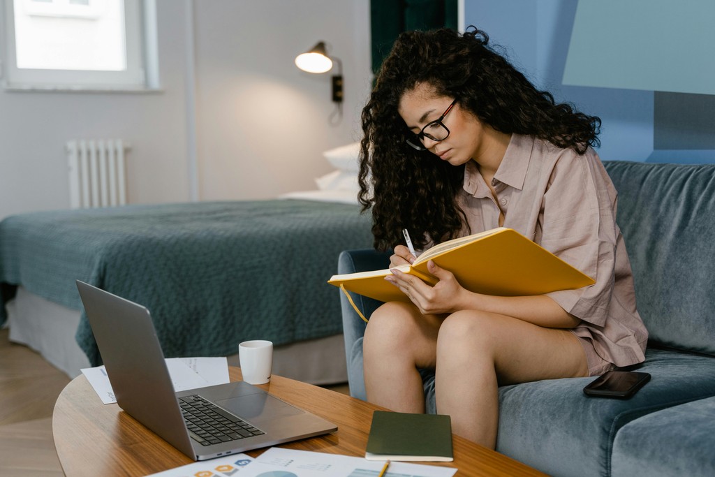 Woman studying on her bed, researching how to format a resume for Canadian recruiters