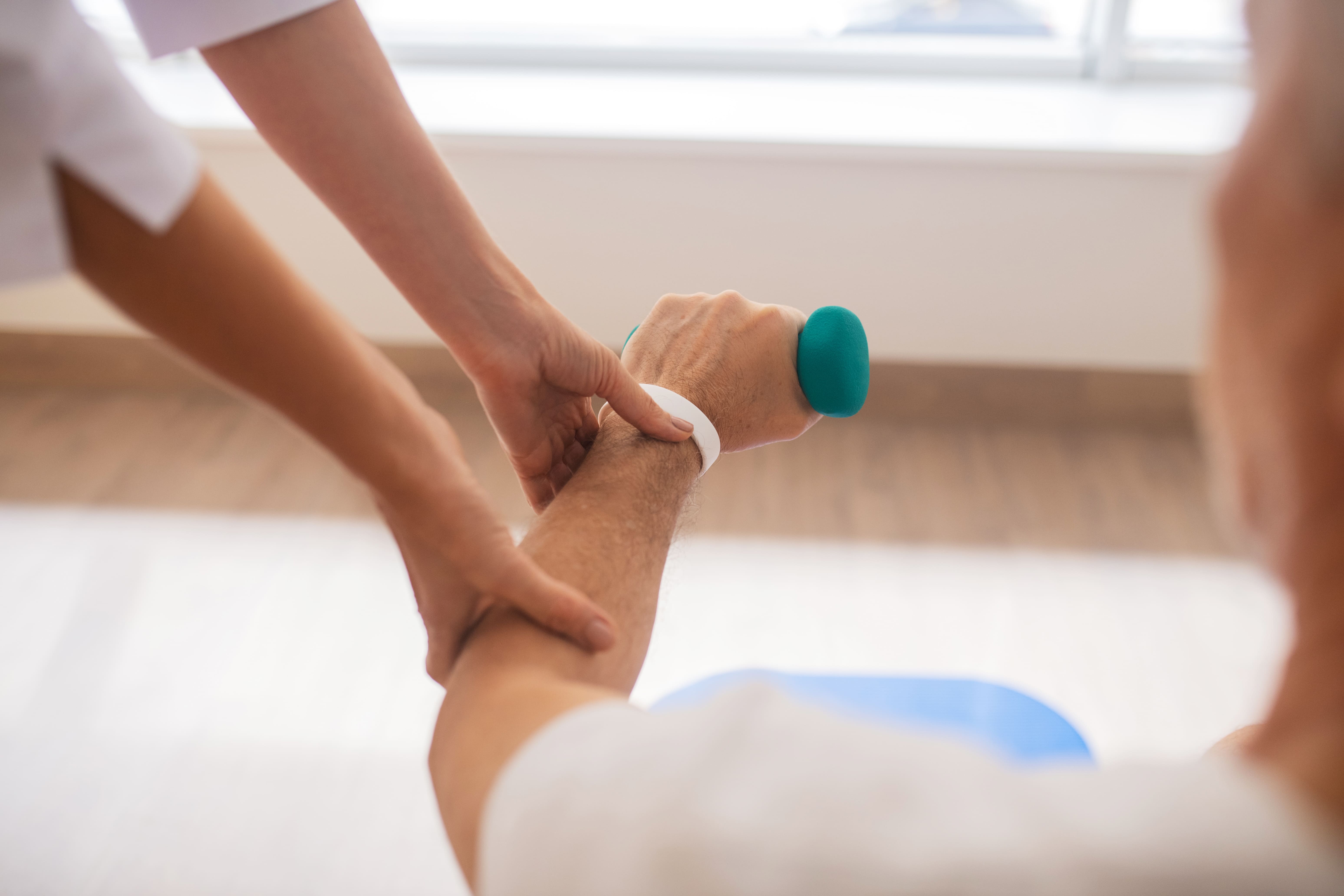 Hand mit Gewichten DG Physio