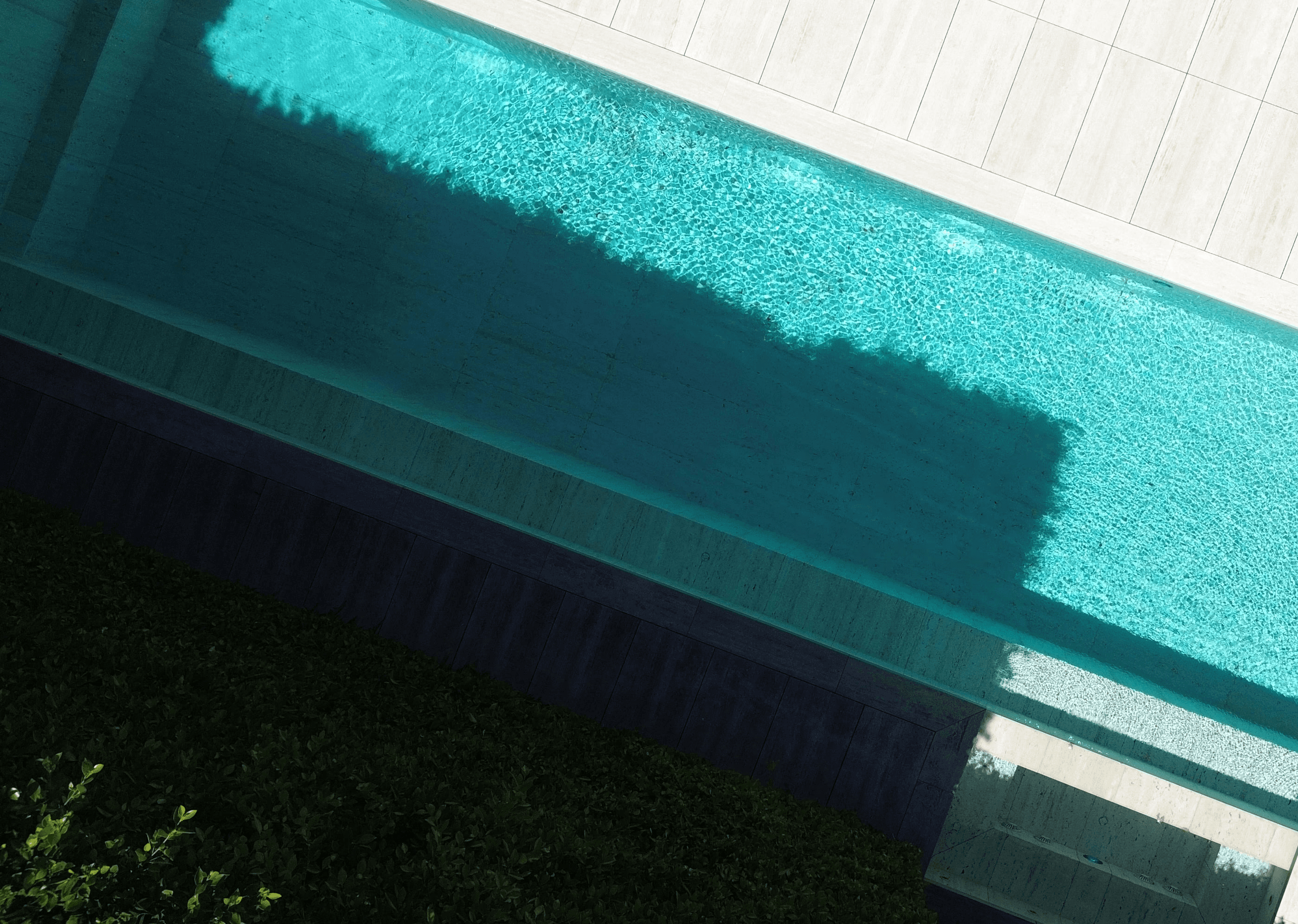 An aerial view of a modern rectangular swimming pool.