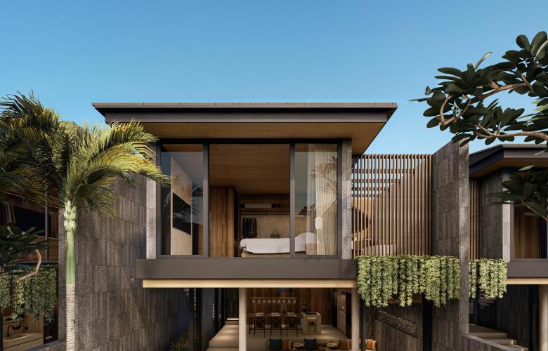 Curved architectural design of a luxury Canggu home with a turquoise pool and sun loungers.